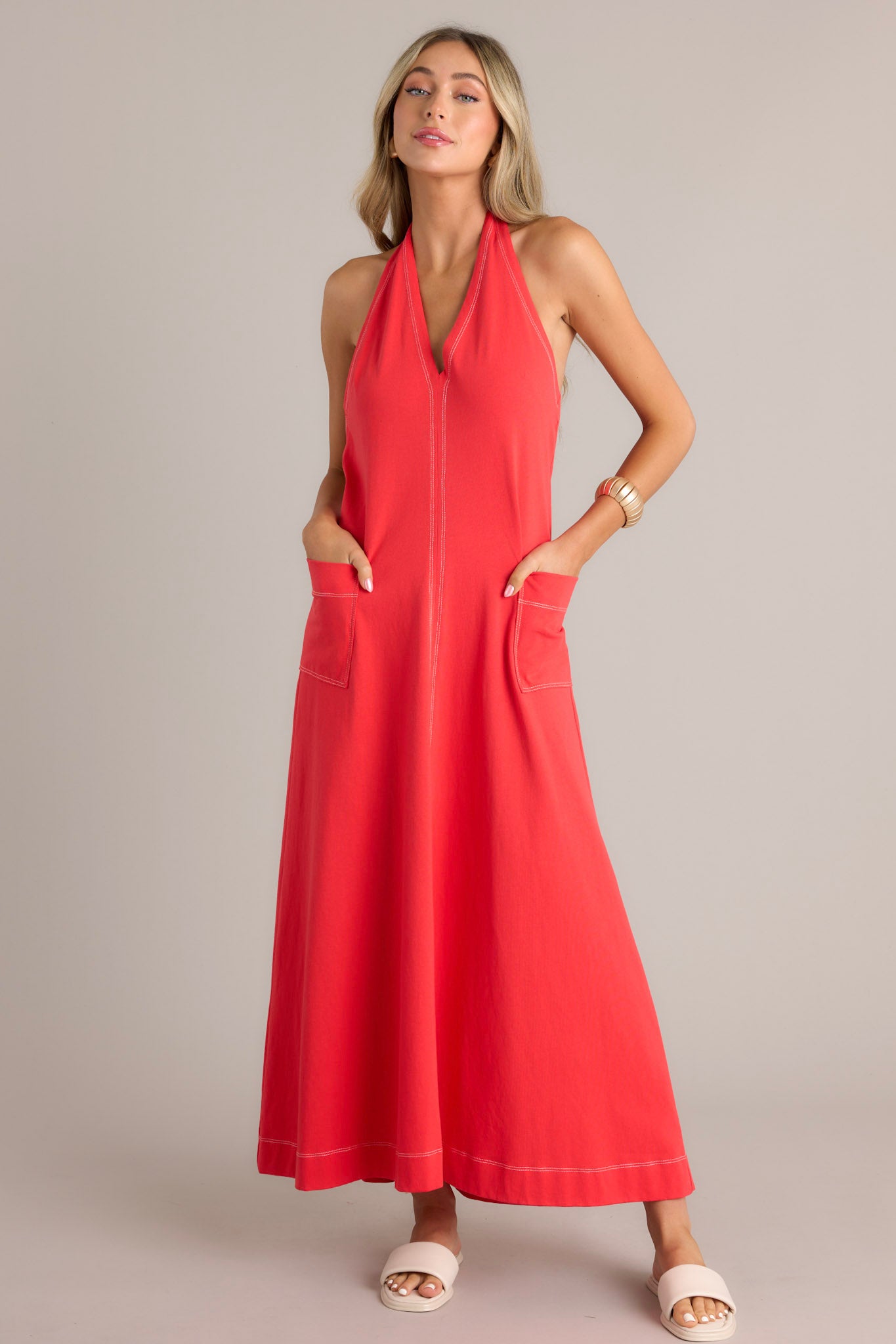 Full body front view of this Casual red maxi dress with contrast stitching, V-neck, and large front pockets.