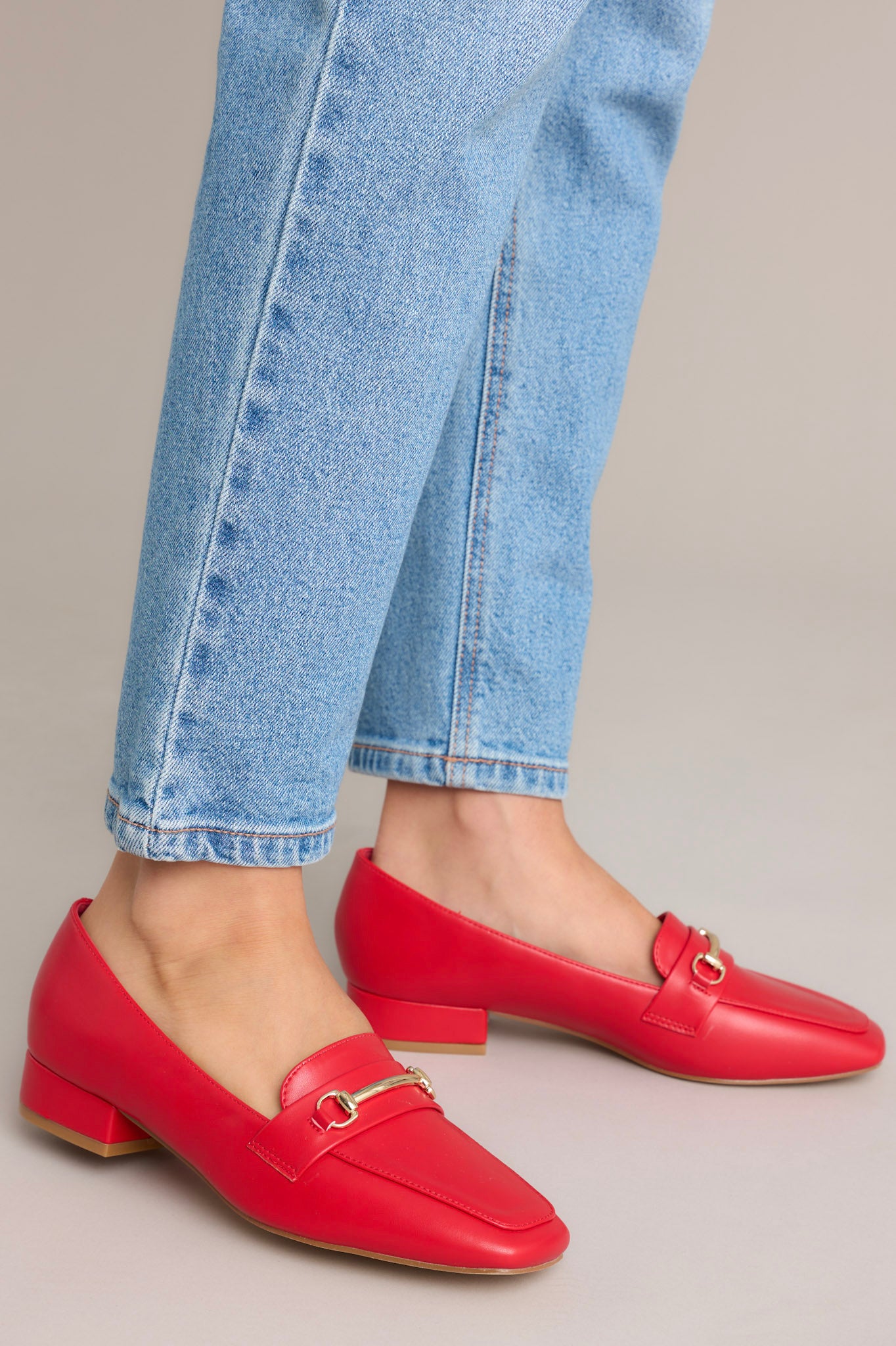 These red loafers feature a slip on design, a small heel, a square toe, and gold hardware.