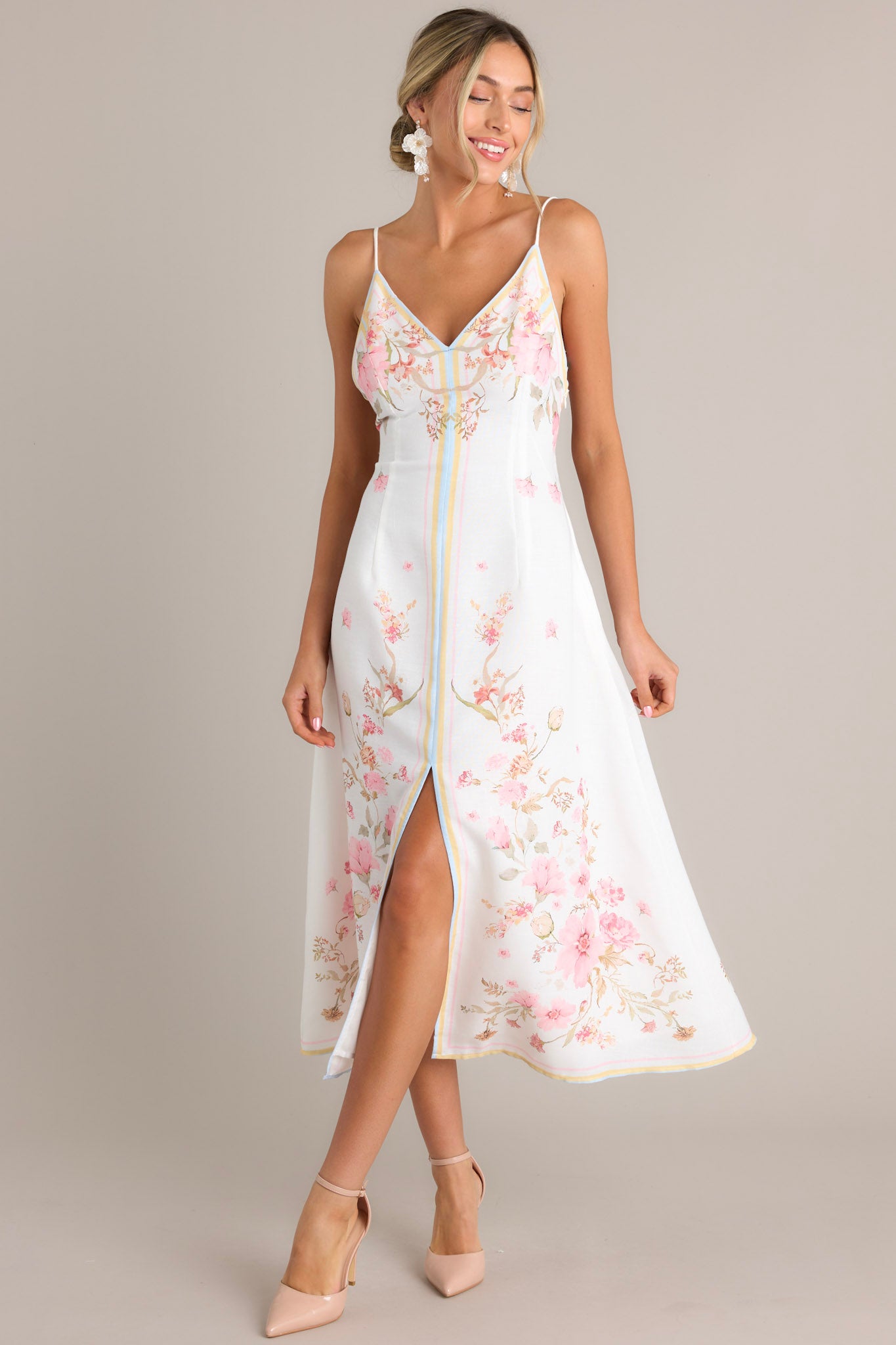 Front view of this floral midi dress that features a v-neckline, thin adjustable self-tie straps, an open back, a discrete side zipper, a delicate floral pattern, and a front slit.