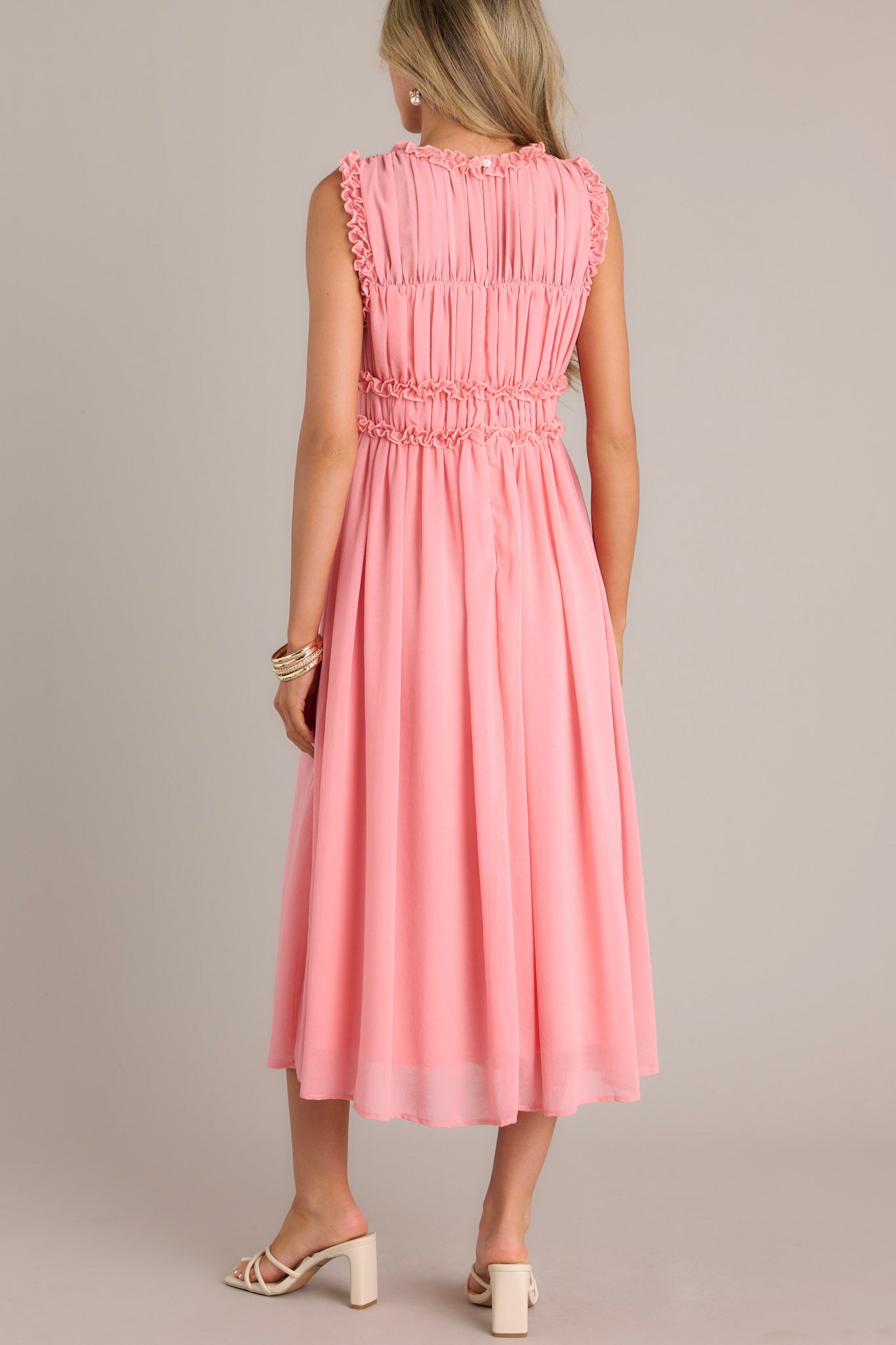 Back view of the pink coral dress showing the high neckline, keyhole opening, and back zipper.