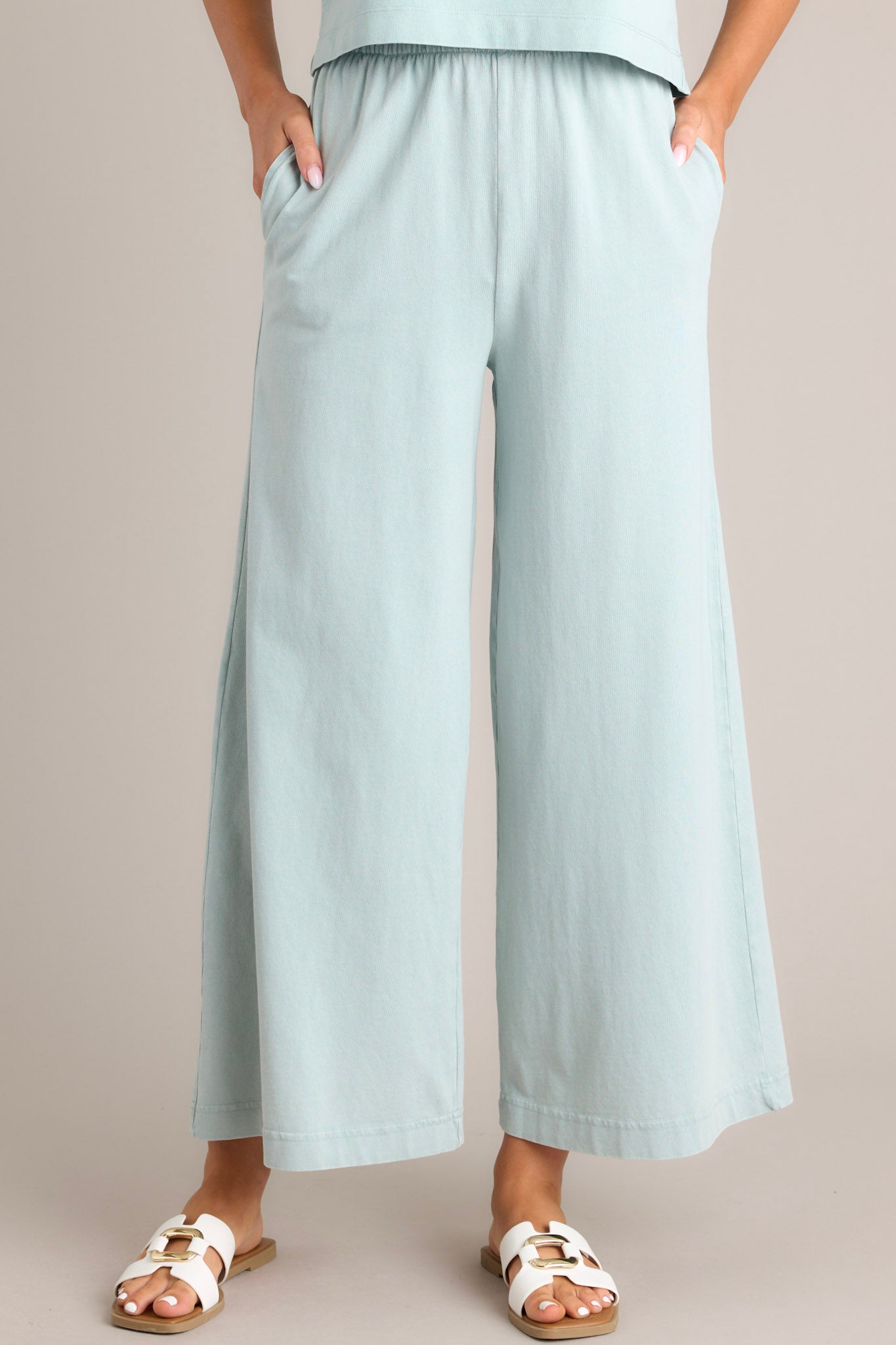 Front view of harbor gray flare pants featuring an elastic waistband, functional pockets, a wide leg design, and a soft jersey material.