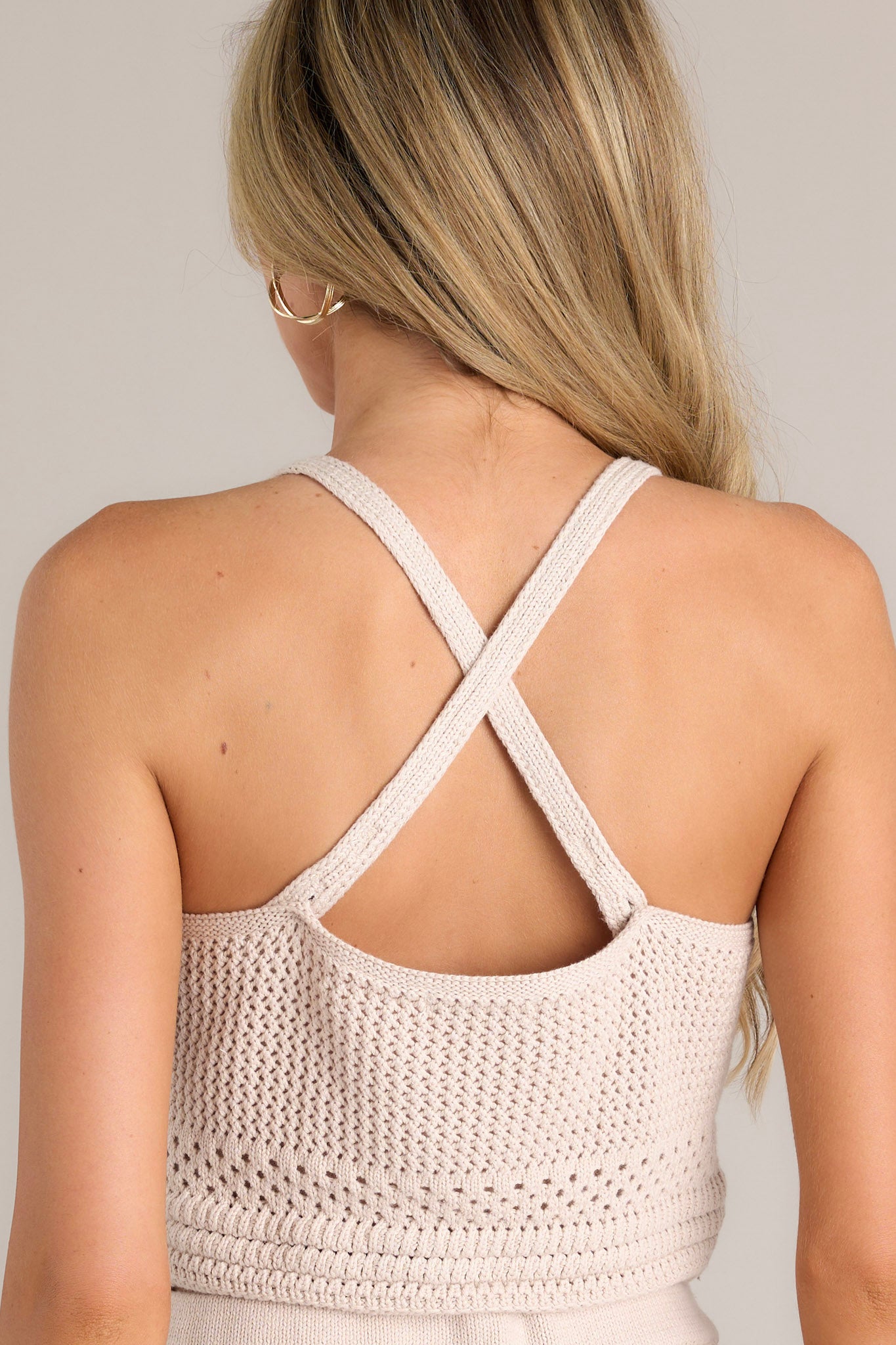 Back view of this natural crochet tank that features a cropped style, a natural crochet design, and thin adjustable straps.