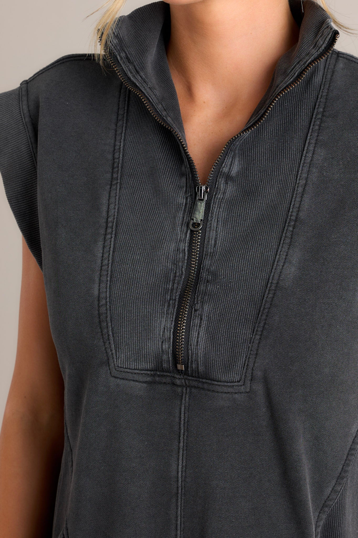 Close-up of the charcoal mini dress showing the collared v-neckline, functional zipper front, ribbed detailing, and functional front pockets.