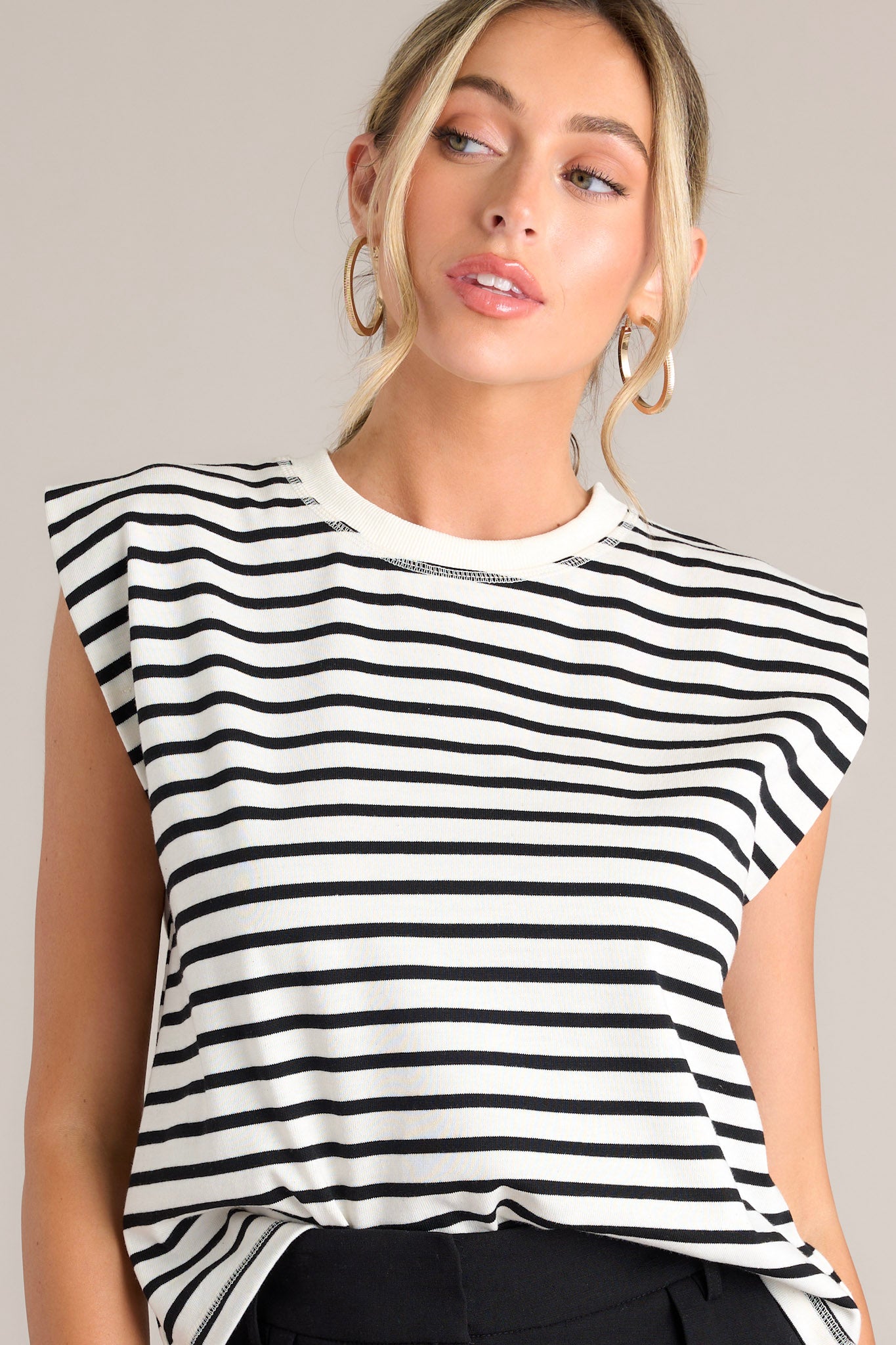 This white stripe top features a crew neckline, short cap sleeves, and a classic stripe pattern.