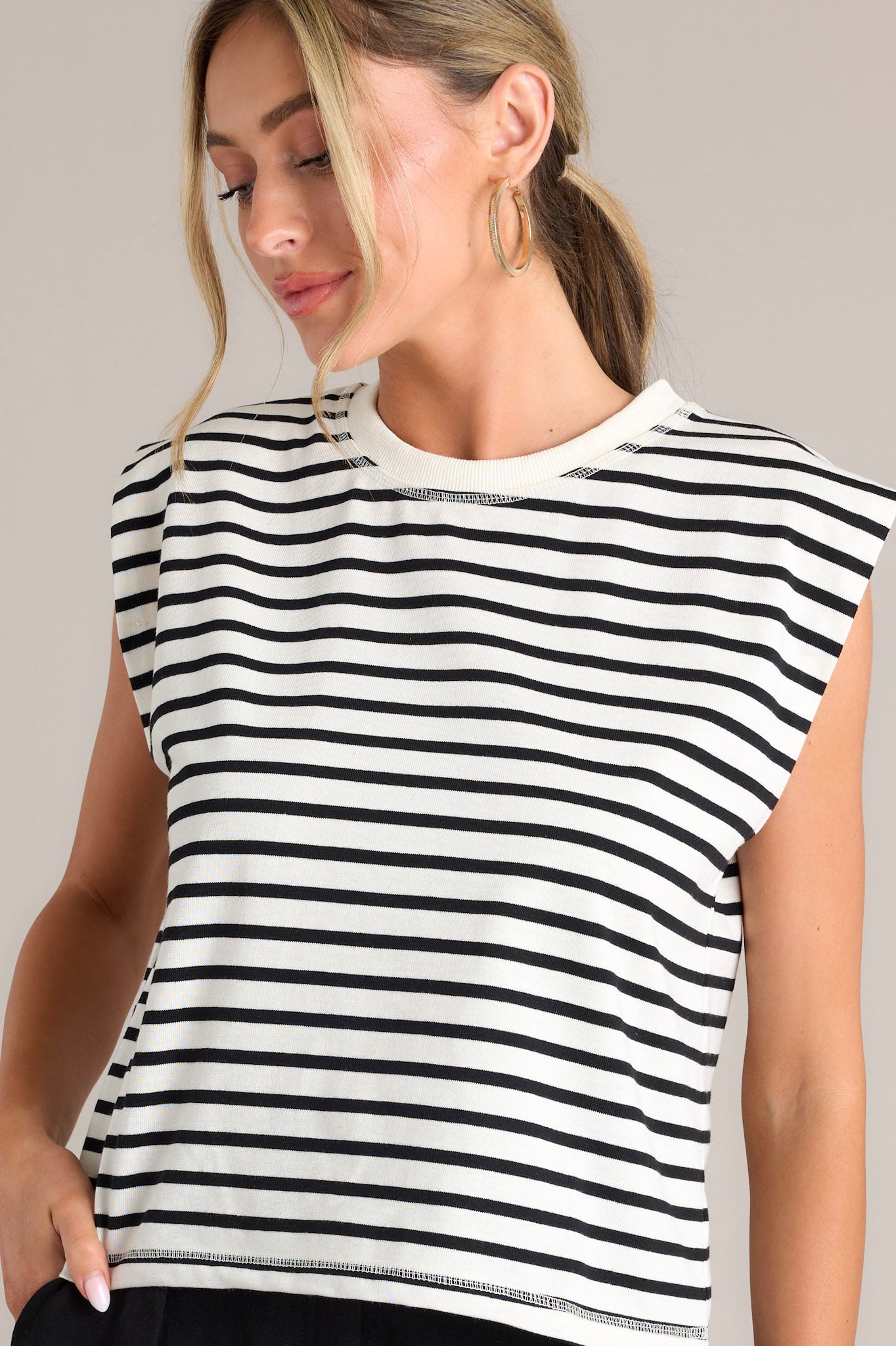 Close up front view of this white stripe top that features a crew neckline, short cap sleeves, and a classic stripe pattern.