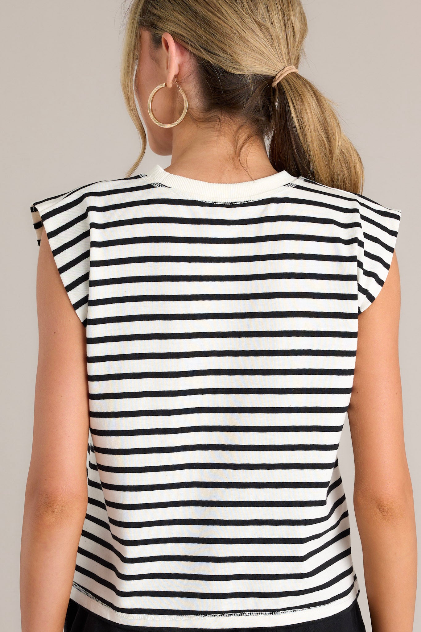 Back view of this white stripe top that features a crew neckline, short cap sleeves, and a classic stripe pattern.