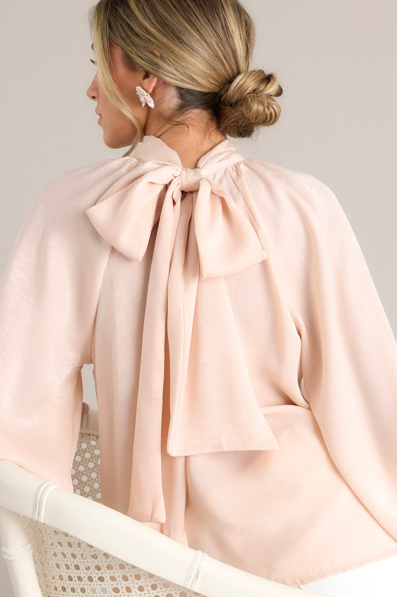 Back view of the top highlighting the high neckline, the adjustable self-tie around the neck, and the flowy silhouette.