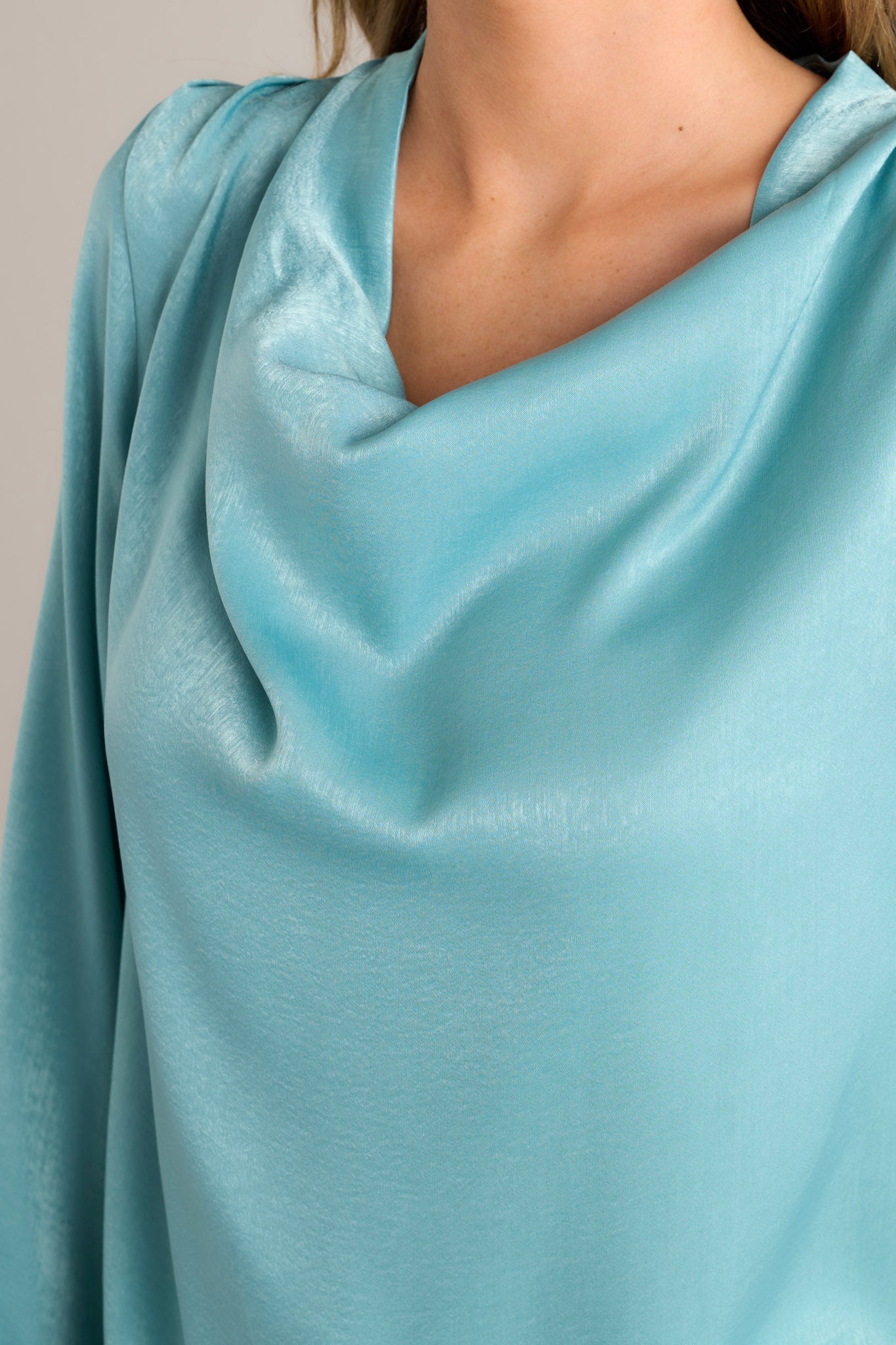 Close up view of this top that features a high cowl neckline and a stunning shiny satin material. 