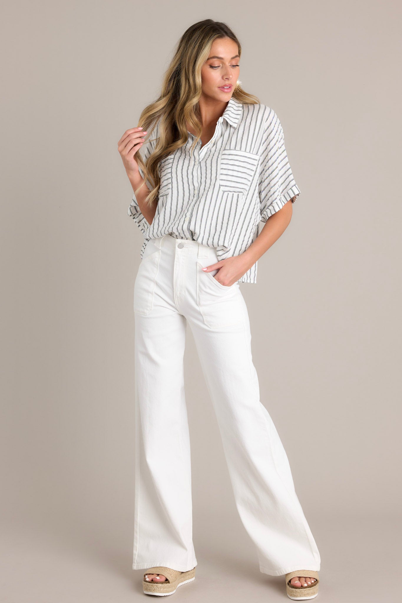 Front angled view of a black stripe top featuring a collared neckline, a functional button front, functional breast pockets, vertical & horizontal stripes, and short cuffed dolman sleeves