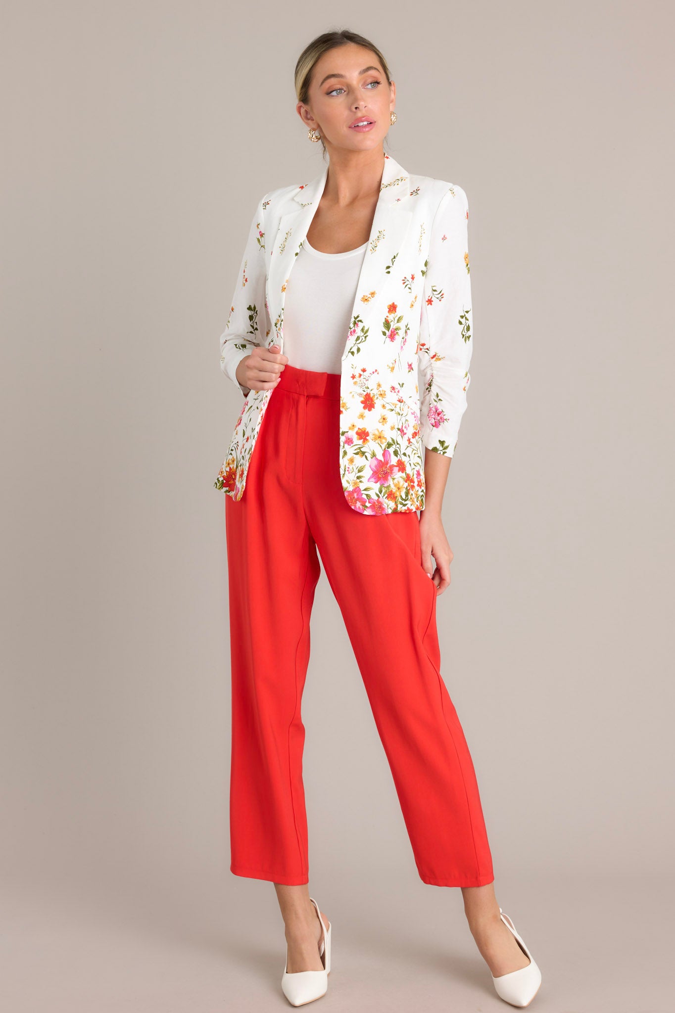 Full length view of a blazer with a lapel collar, faux front pockets, 3/4 sleeves with a ruched detail, and a floral pattern throughout