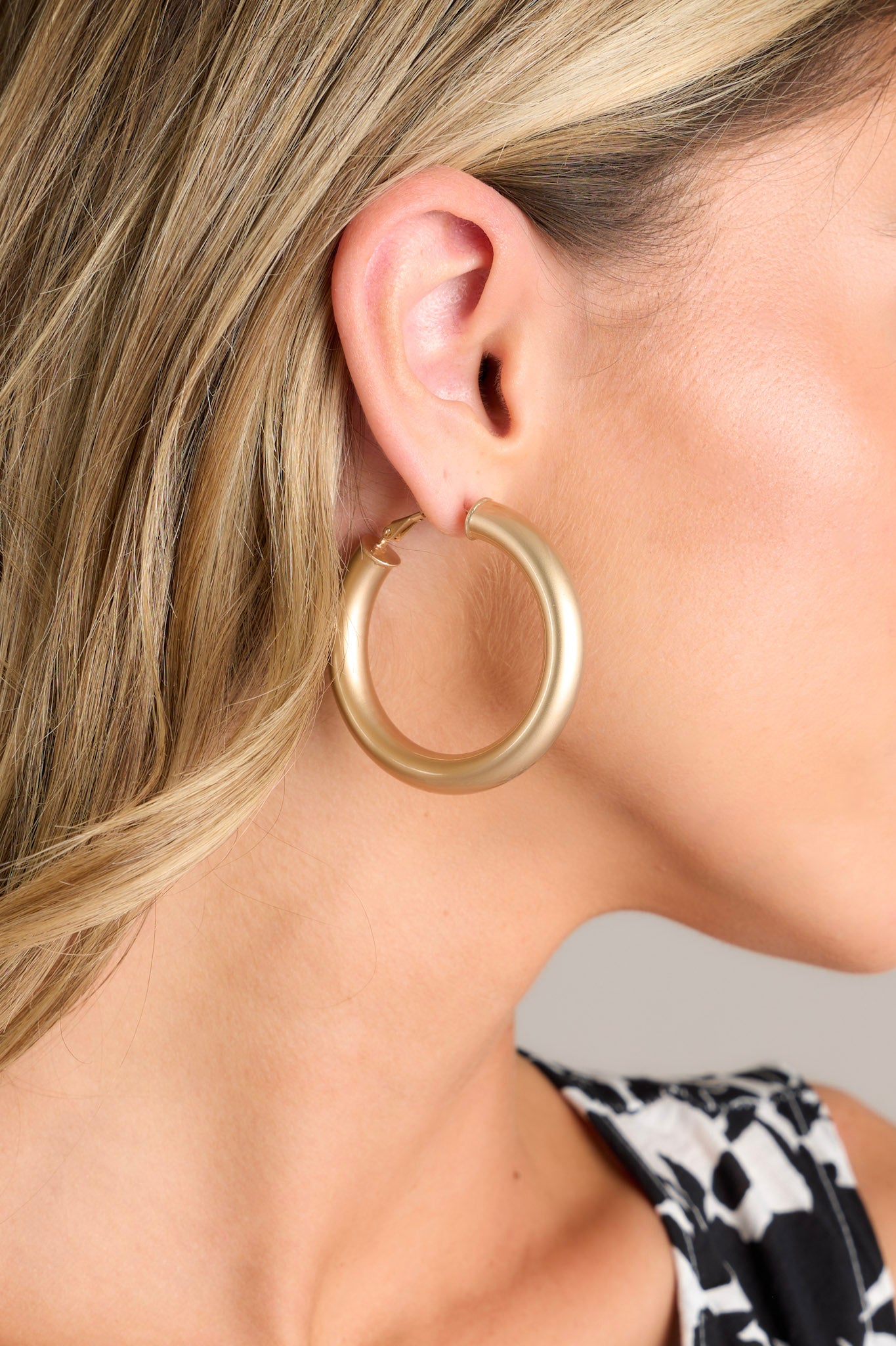 The chunky hoops displayed in a close-up, focusing on their medium size and smooth matte finish.