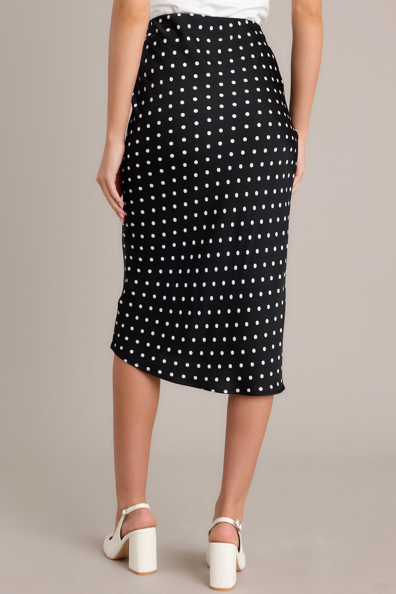 Rear view of the black midi skirt emphasizing the high-waisted design and smooth, flattering fit.