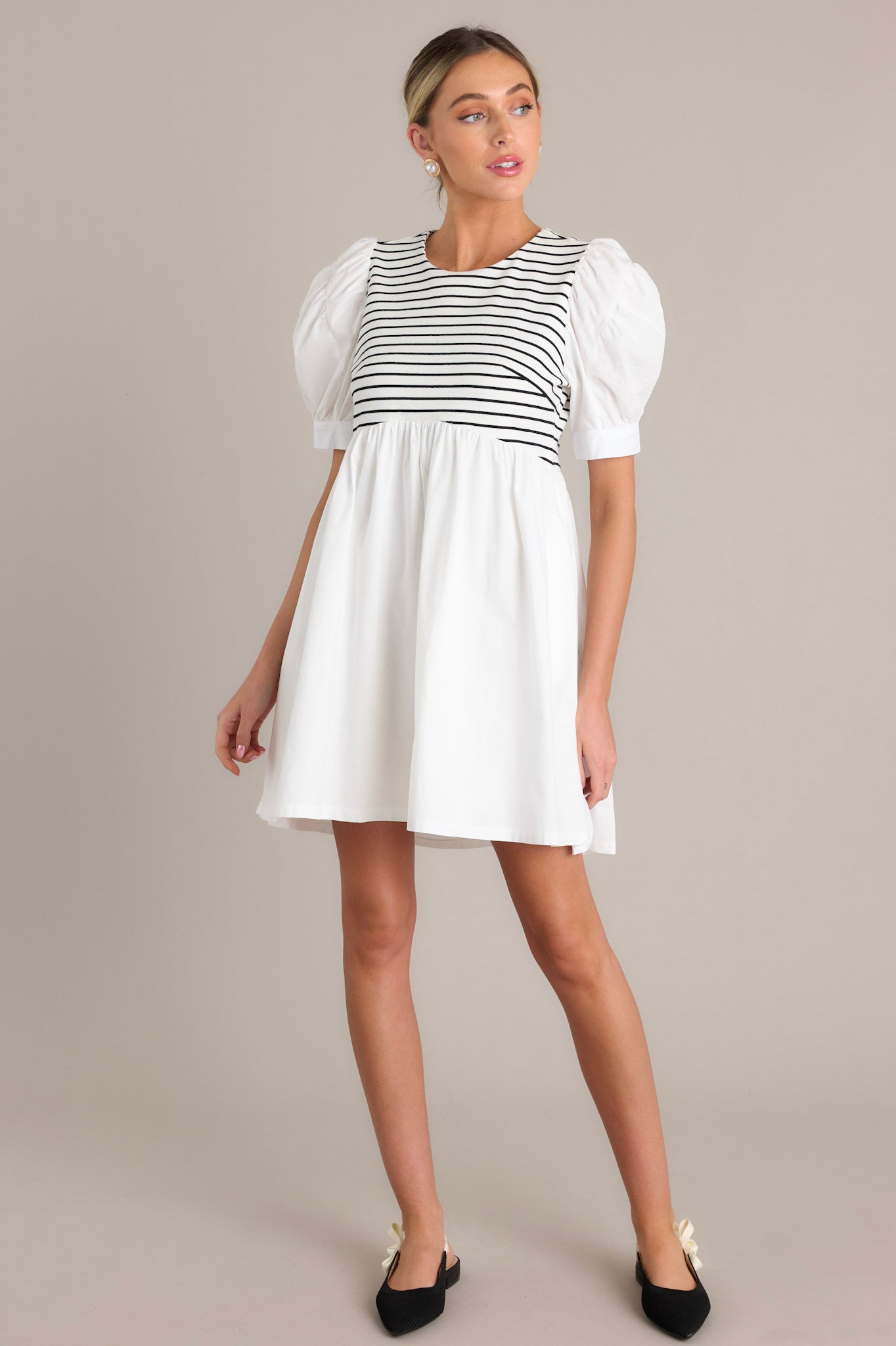 This white dress features horizontal black and white stripes on the bodice and white puffed sleeves.