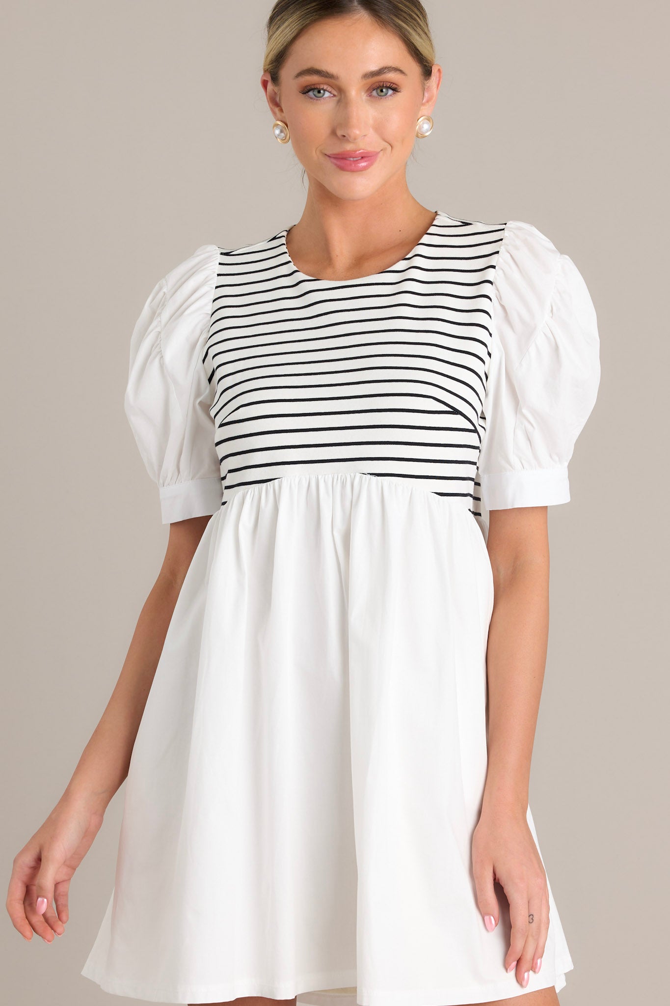 This casual white dress with a black and white striped bodice and voluminous puff sleeves.