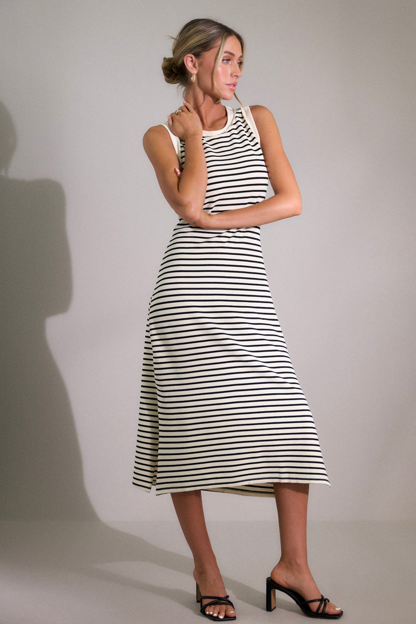 Full body view of this stripe midi dress that features a crew neckline, a classic horizontal stripe design, and a split hemline.