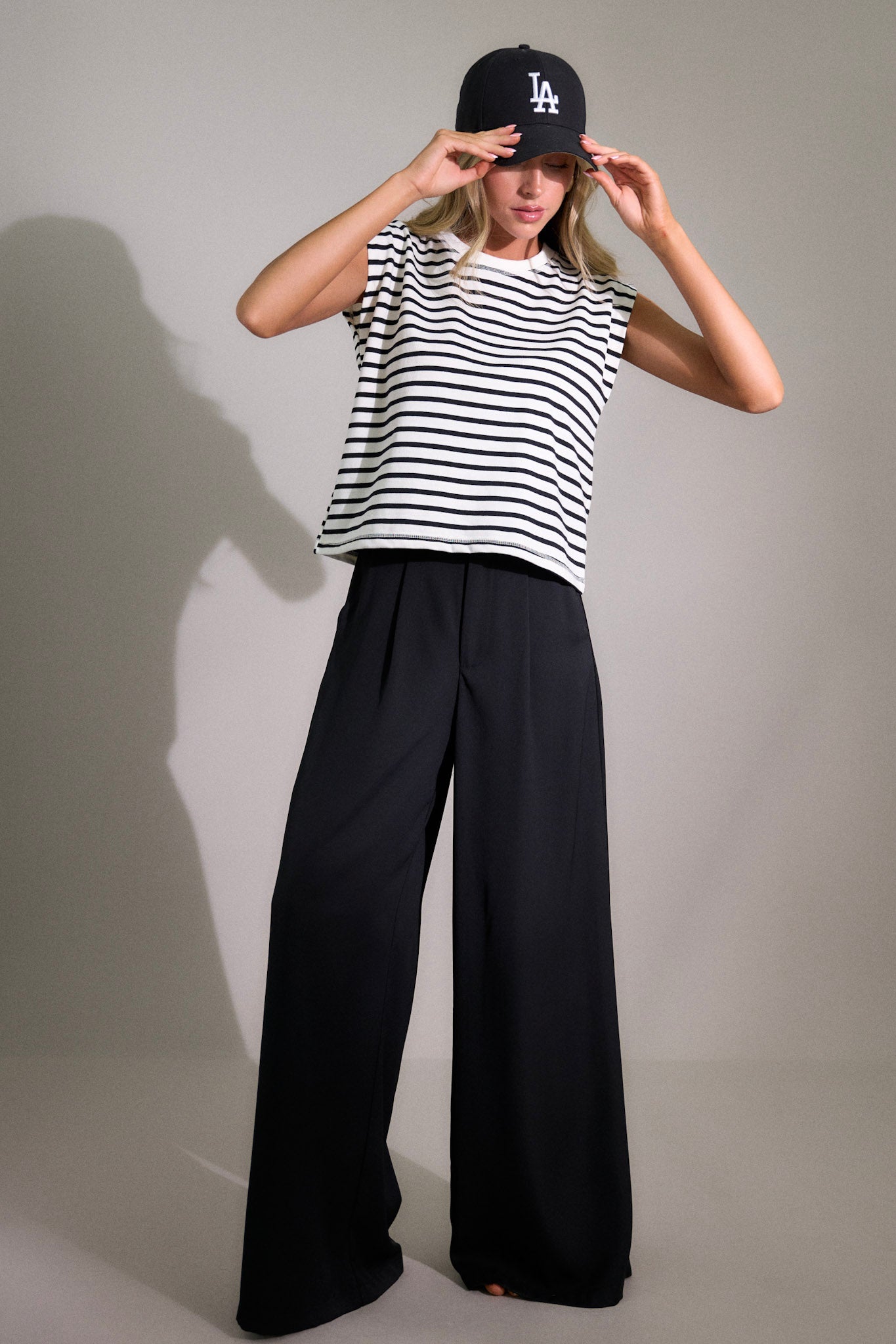 Full body view of this white stripe top that features a crew neckline, short cap sleeves, and a classic stripe pattern.
