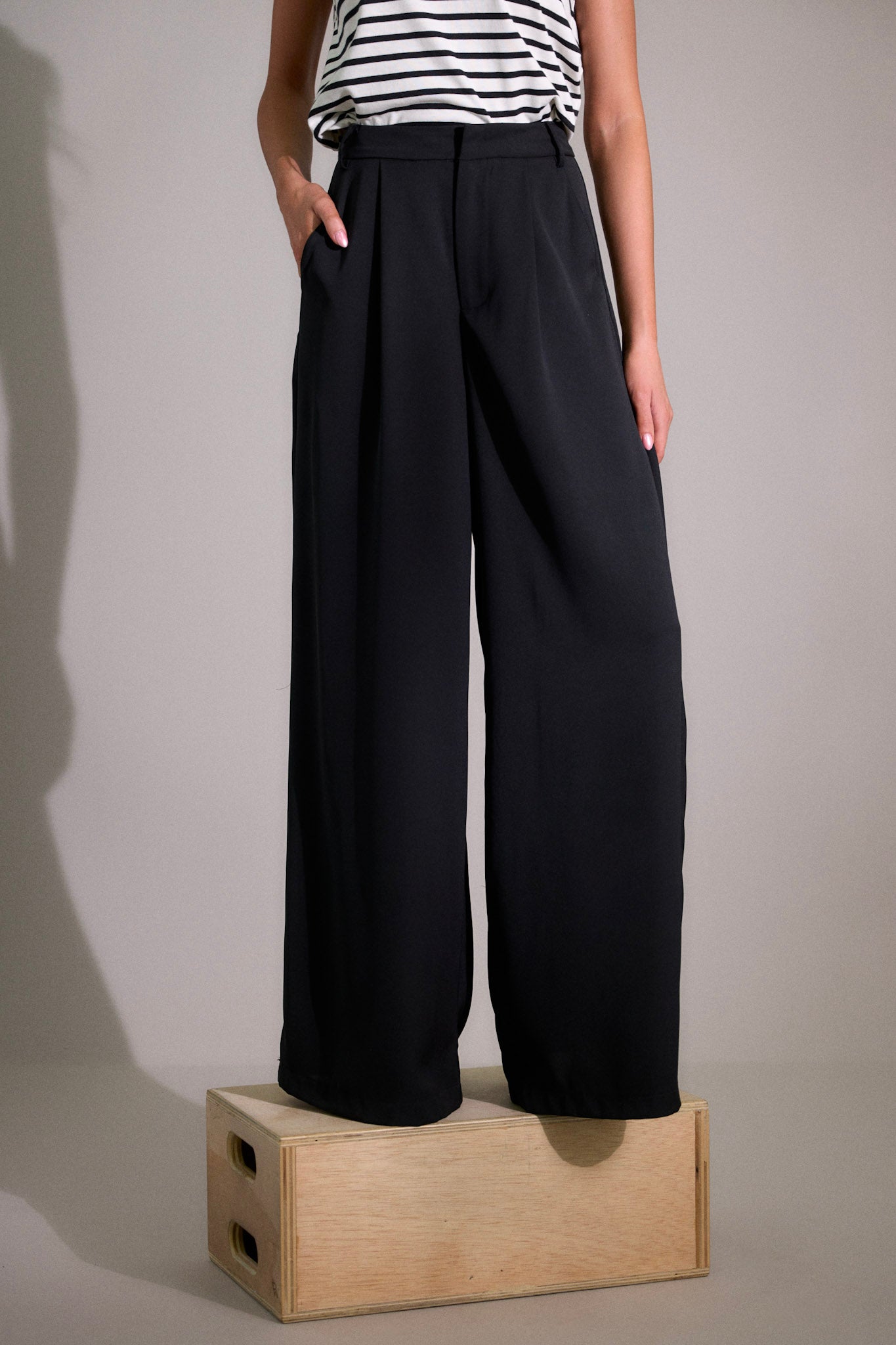 These black pants feature a high waist fit, a hook and bar closure, belt loops, pockets, and a wide leg.