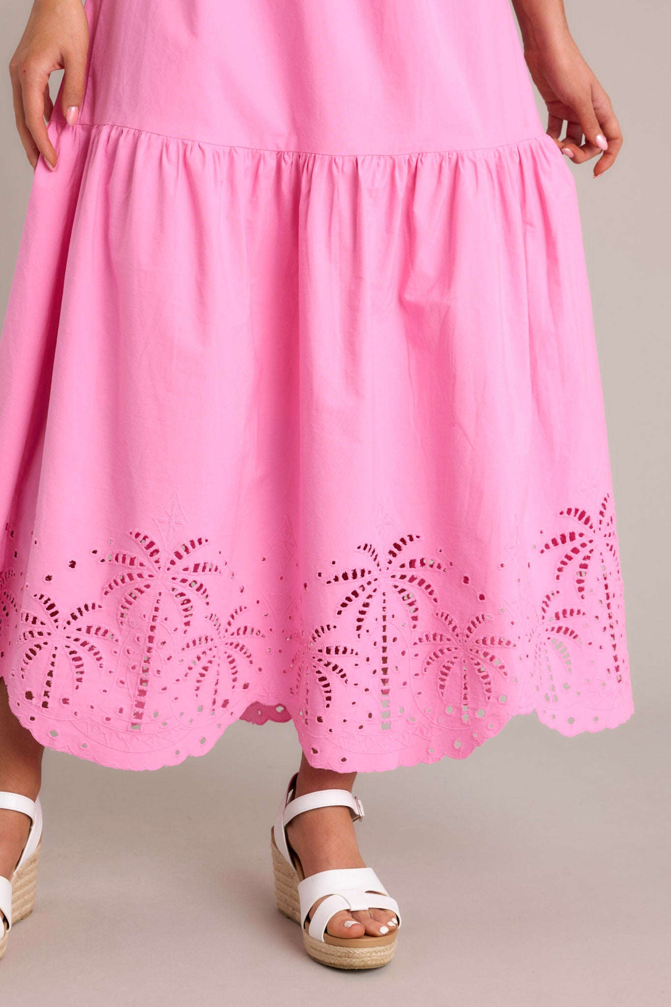 Close-up of the pink midi dress showing the intricate palm eyelet detailing