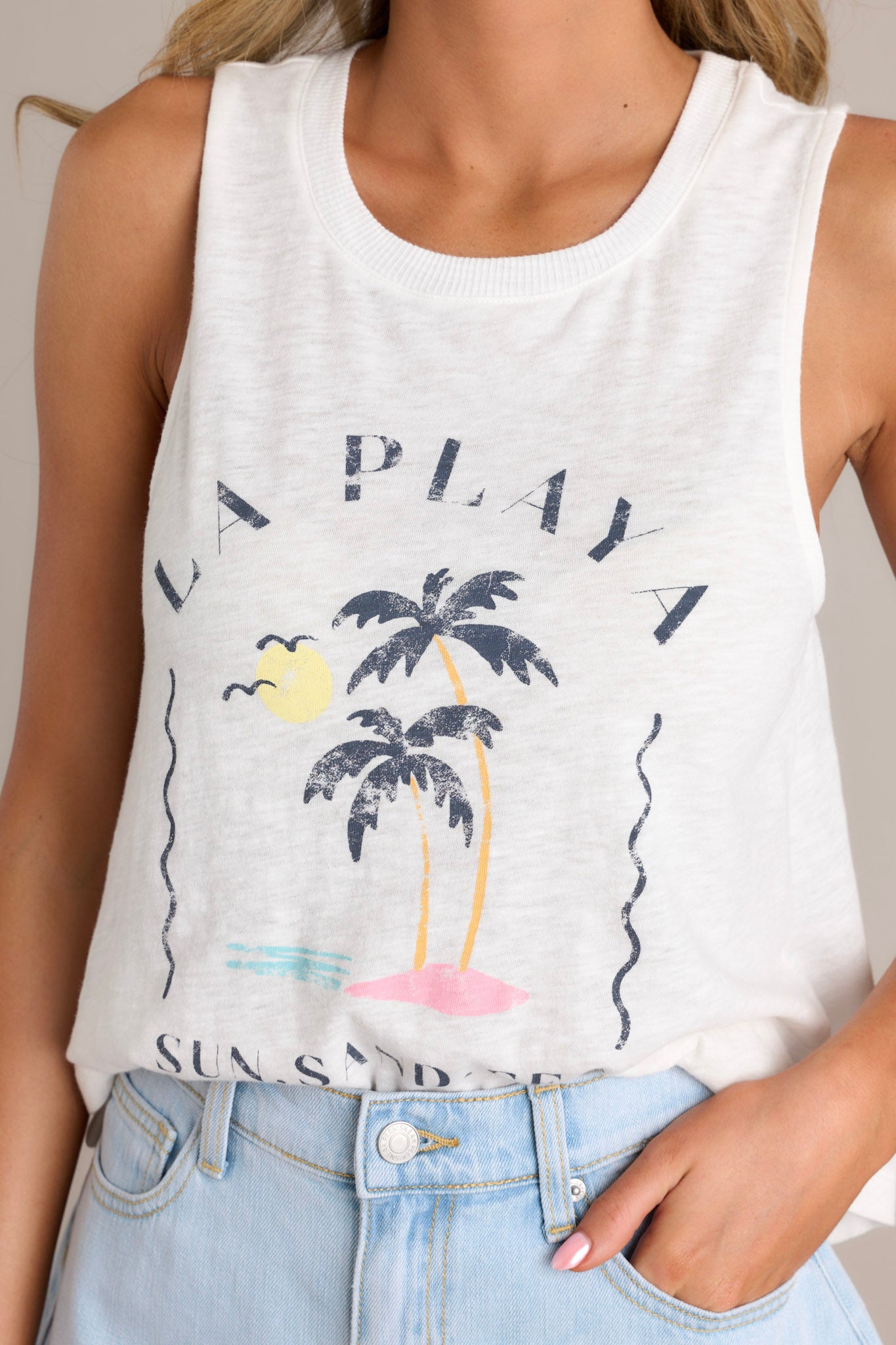 Detailed close-up of the white tank’s front, emphasizing the 'La Playa' & palm graphic and ribbed scoop neckline