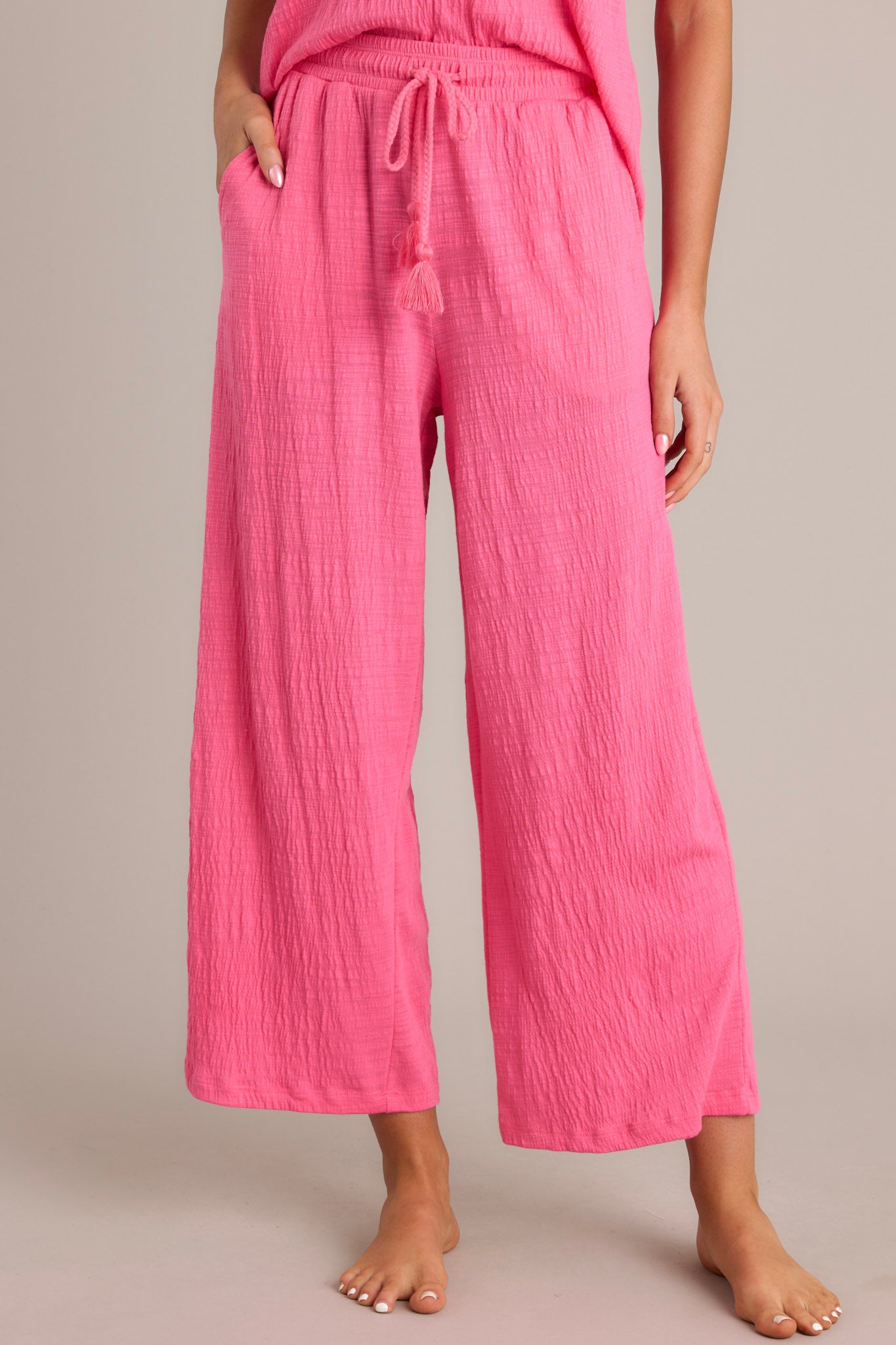 Close-up view of pink pants showcasing the high-waisted design, elastic waistband, and wide leg.