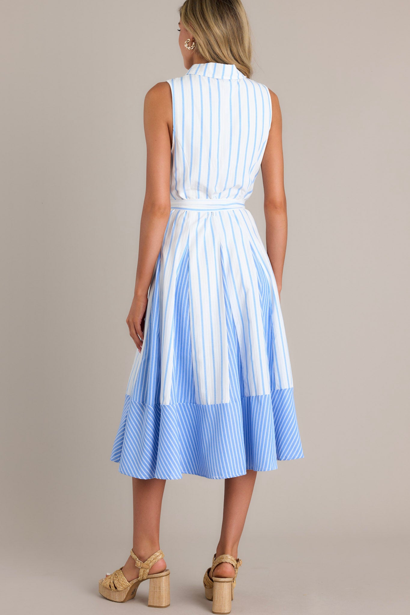 Back view of a light blue midi dress featuring a collared neckline, unique stripe pattern, and flowing silhouette."