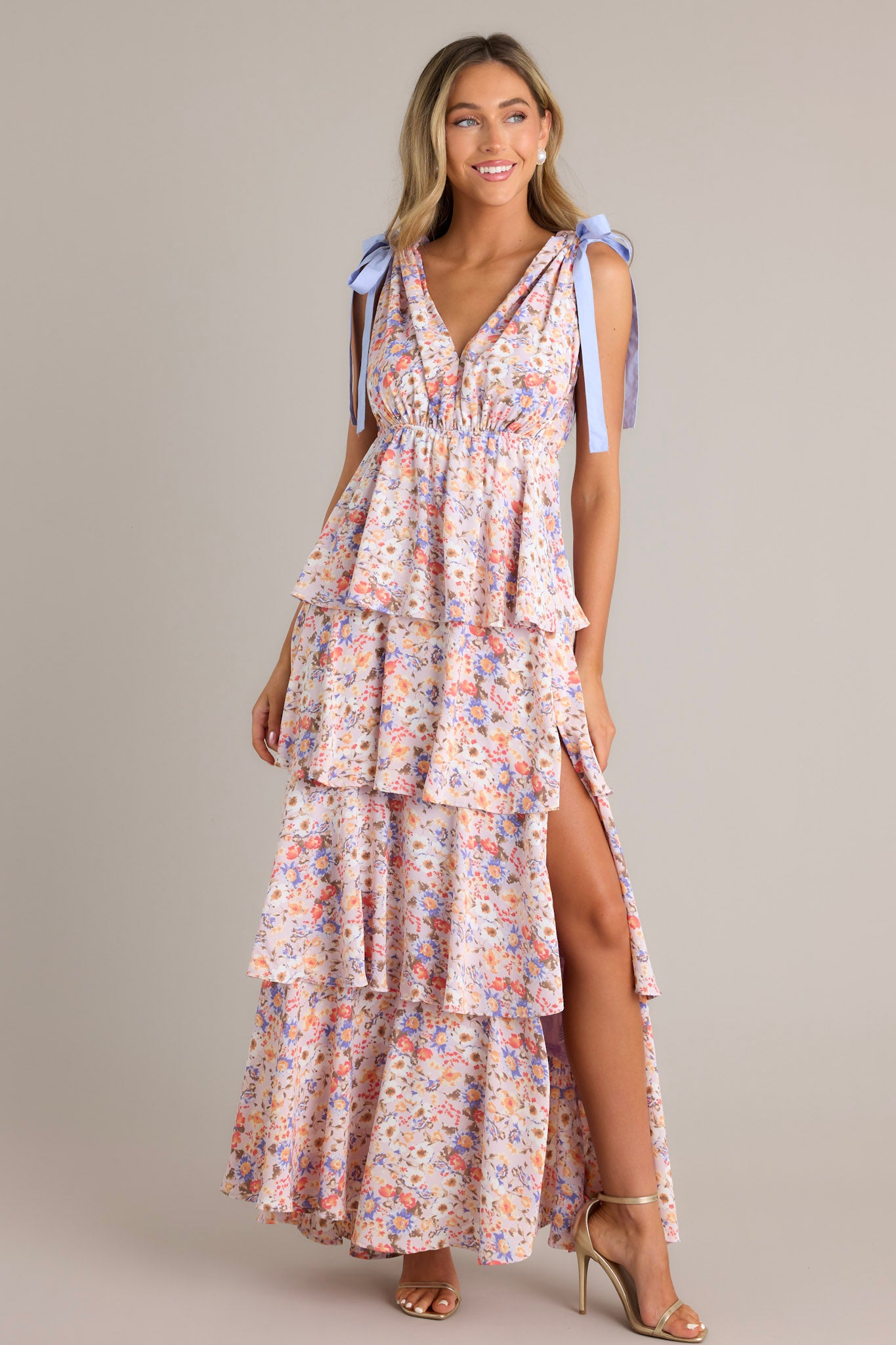 Full-length view of this lavender ruffled maxi dress with floral print and tied shoulder straps, showcasing a thigh-high slit on the side.