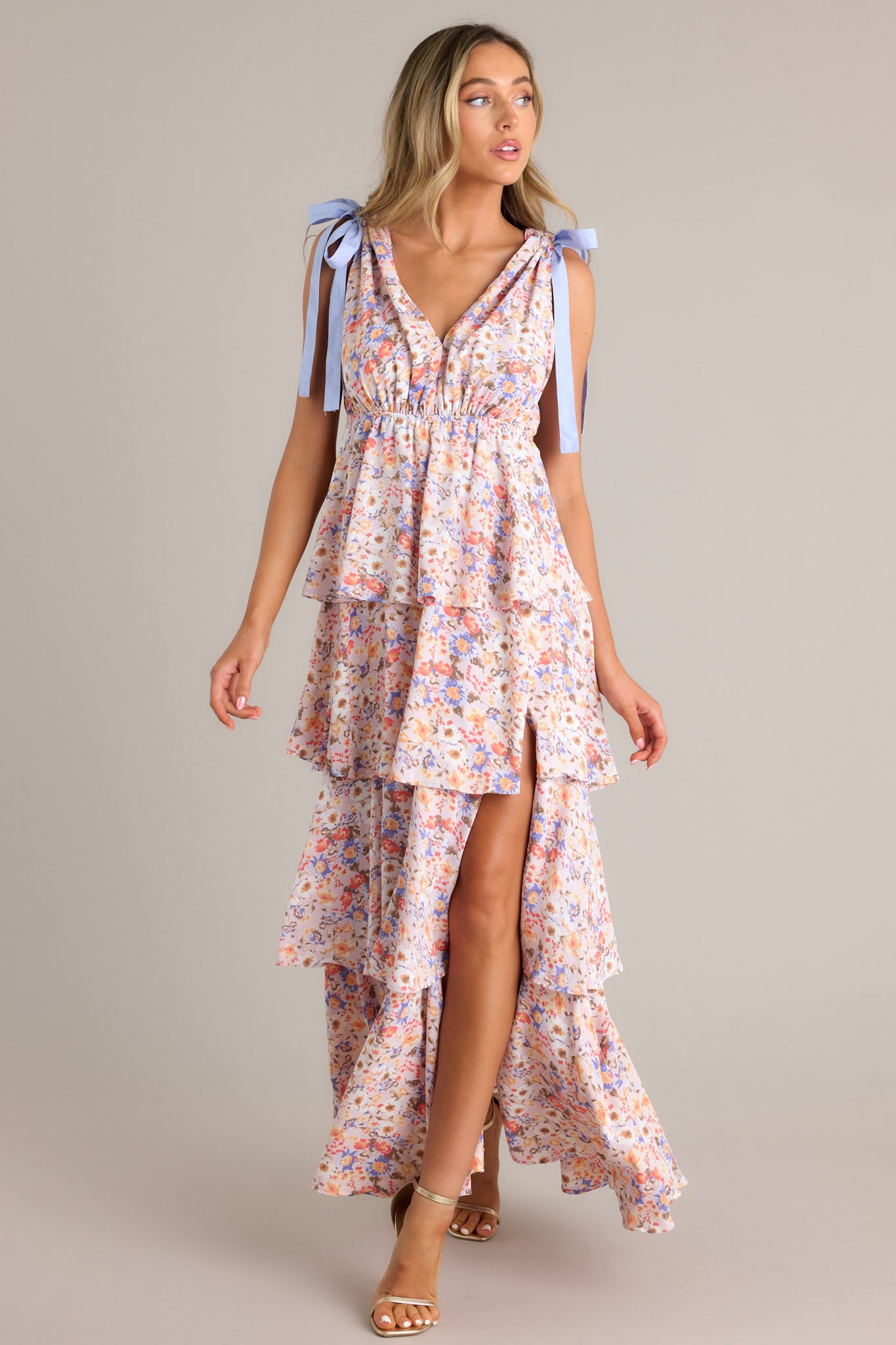 Front view of a lavender tiered ruffle maxi dress with pastel floral design, tied shoulder straps, and a v-neckline, highlighting the layered structure.