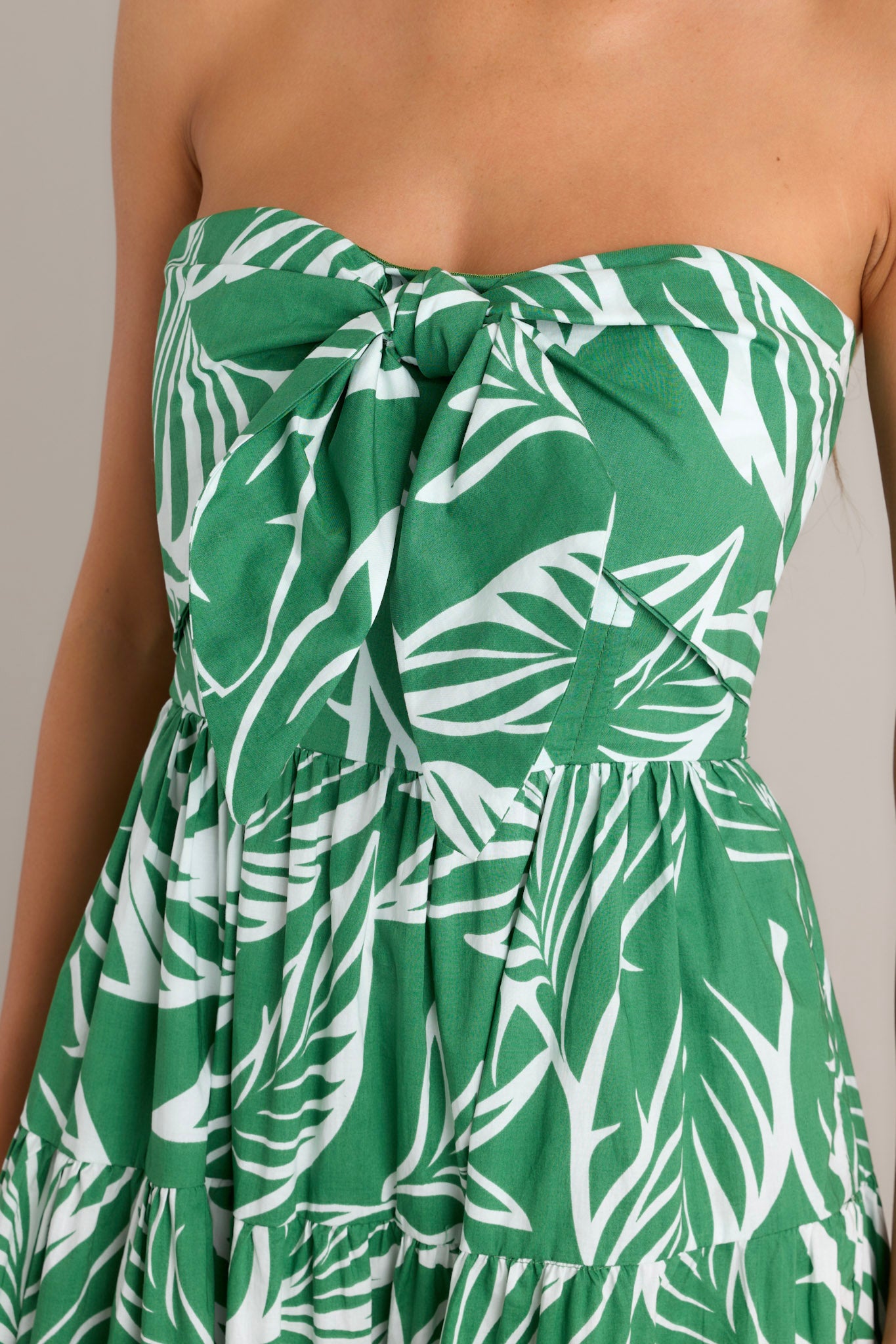 Close-up of the green midi dress showing the boning in the bodice, self-tie feature, and the fully smocked insert in the back.