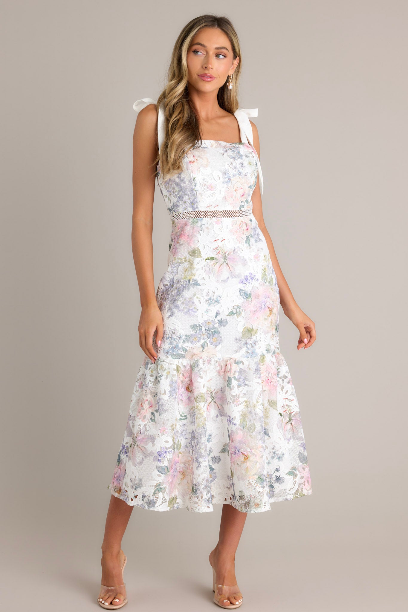 Full body view of this ivory floral midi dress that features a square neckline, self-tie straps, a hidden zipper down the back, a single-tier design, and a lace knitted overlay.