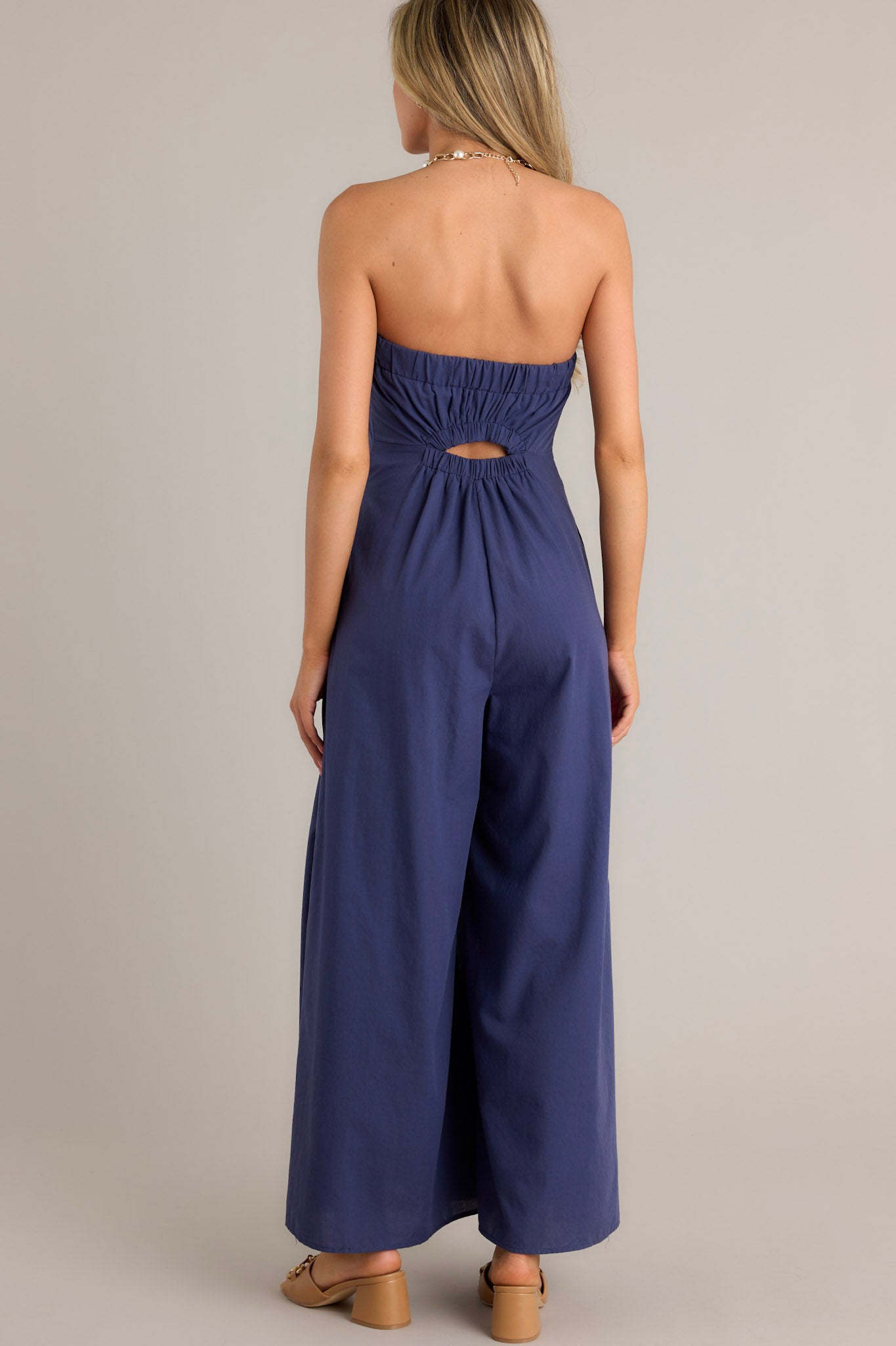 Back view of a navy jumpsuit highlighting the elastic cut-out in the back and the wide leg design.