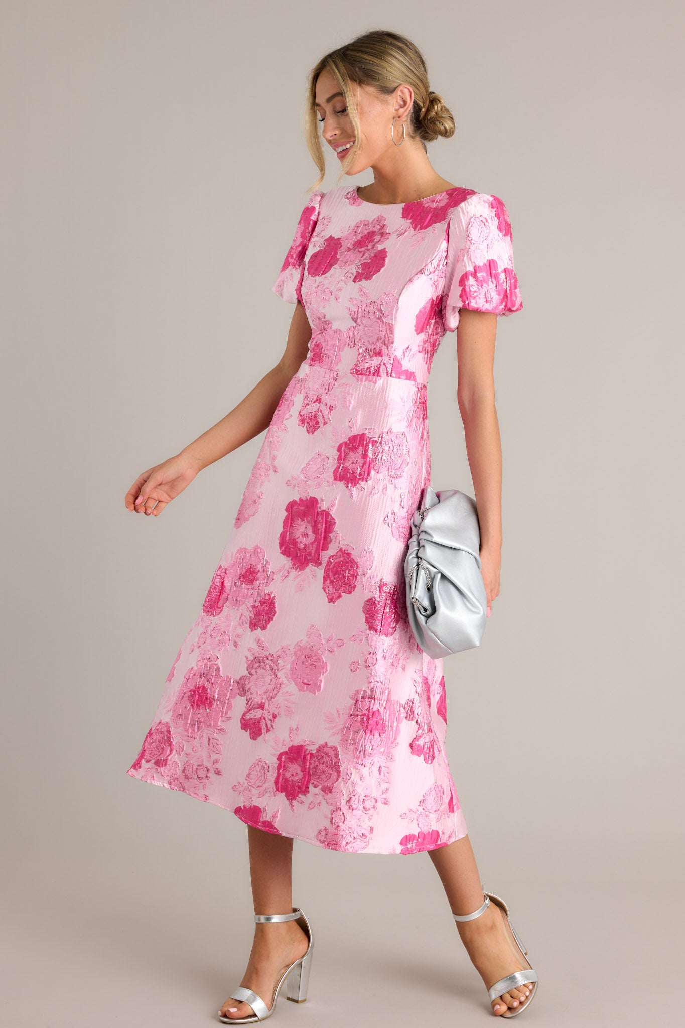 Side view of a pink dress showcasing the boat neckline, short puff sleeves, and midi length.