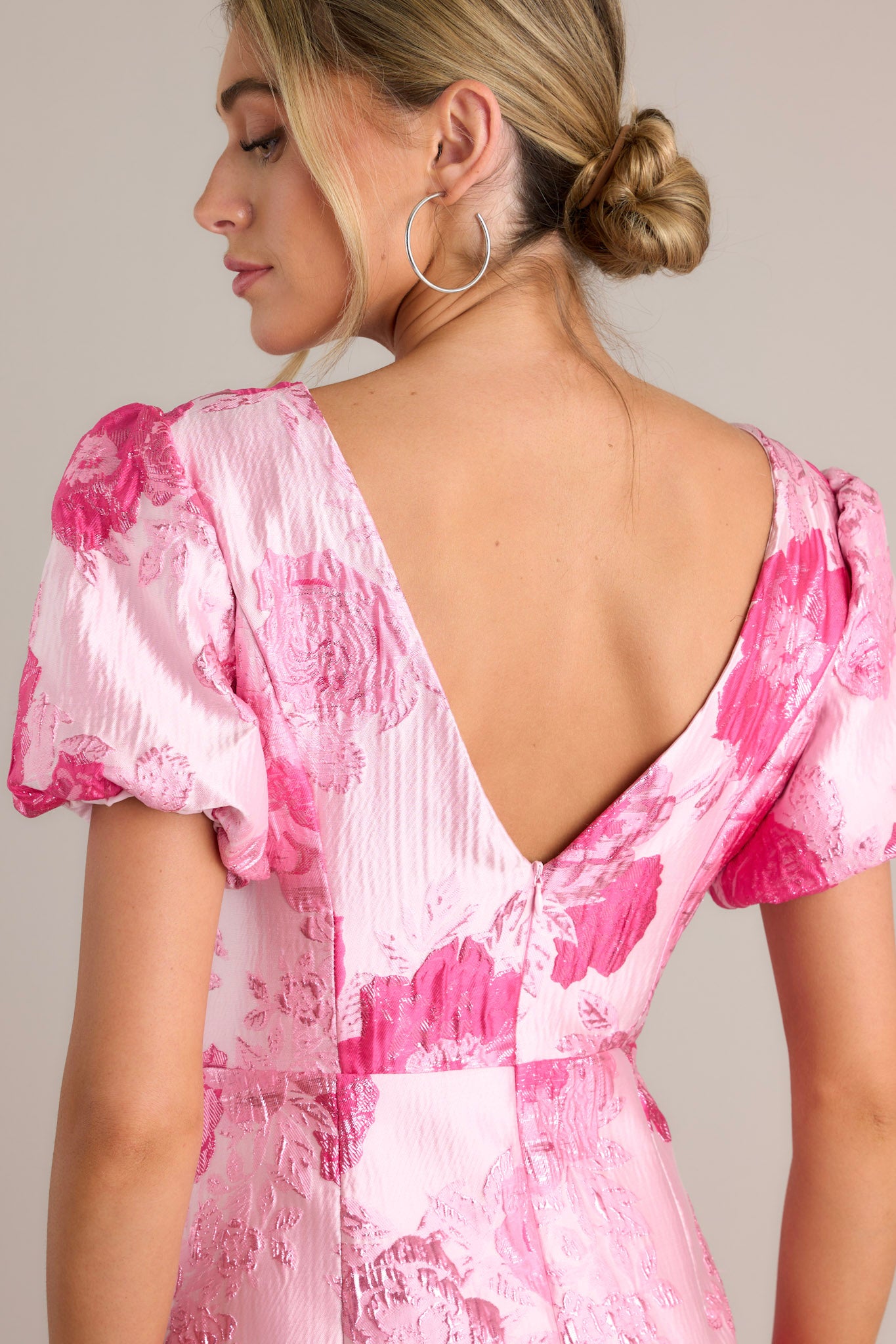 Back view of a pink dress highlighting the deep v-back with a zipper closure and overall fit.