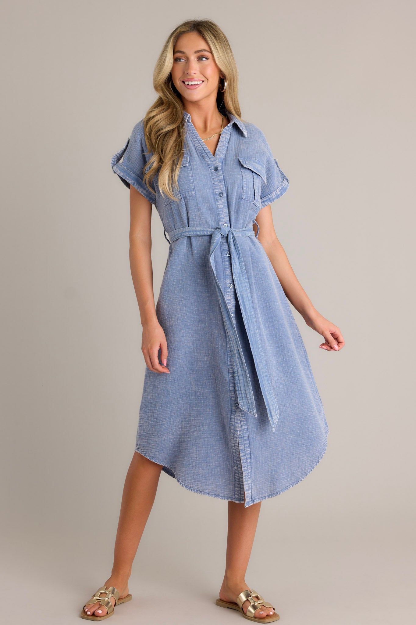 Close-up of the blue maxi dress showing the collared v-neckline, functional button front, functional breast pockets, and self-tie waist belt.