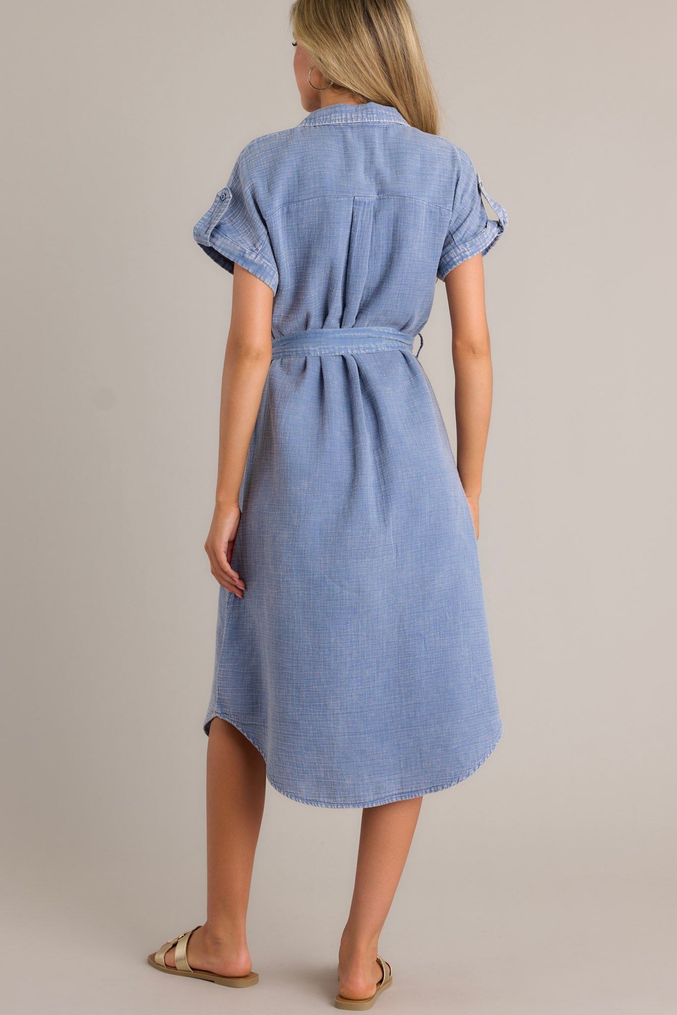 Back view of a blue maxi dress highlighting the self-tie waist belt, belt loops, and overall fit.