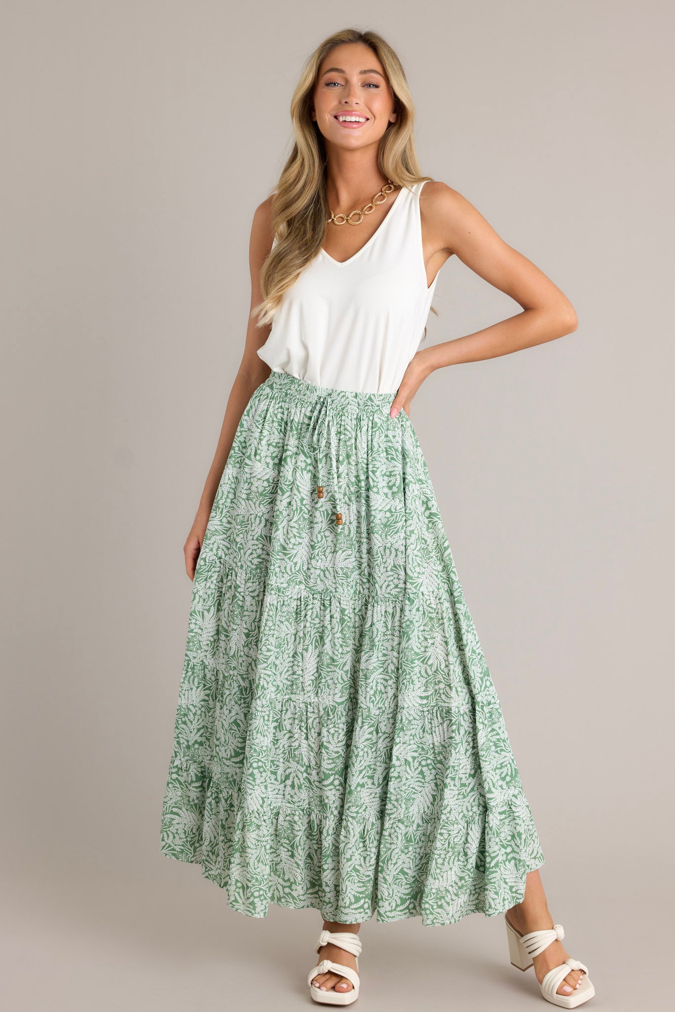 This green maxi skirt features a high waisted design, an elastic waistband, a self-tie drawstring, multi tiers, and a flowing silhouette.