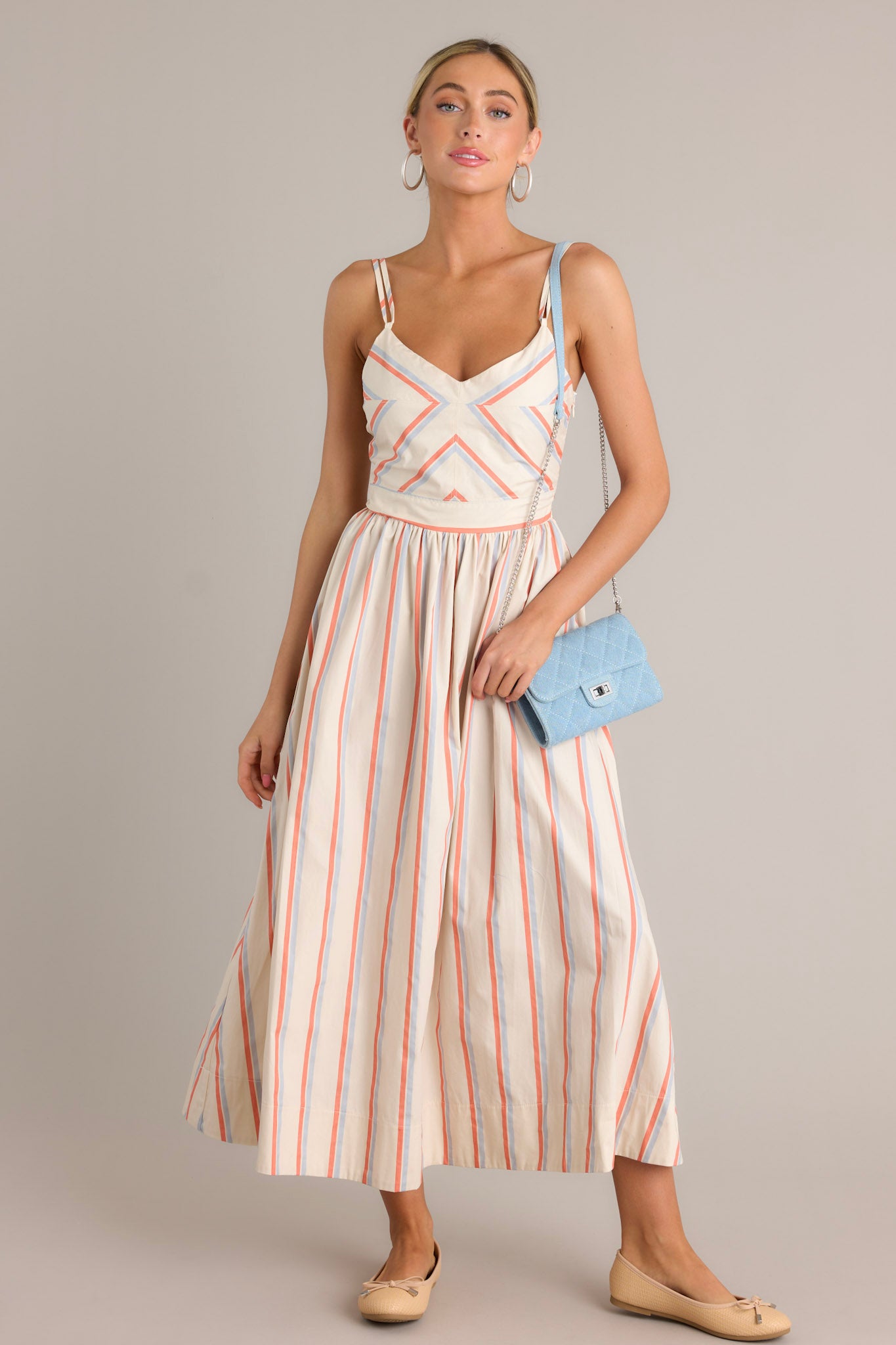 This multi stripe dress features a v-neckline, thin adjustable double straps, a smocked back insert, a discrete side zipper, a flowing silhouette and thick hemline.