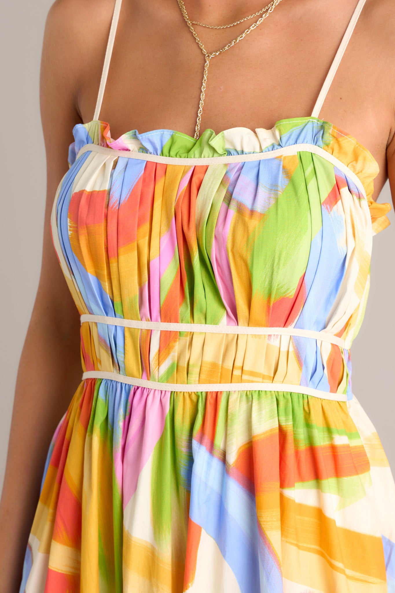 Close-up of the yellow multi maxi dress showing the square neckline, pleated chest, and functional hip pockets.
