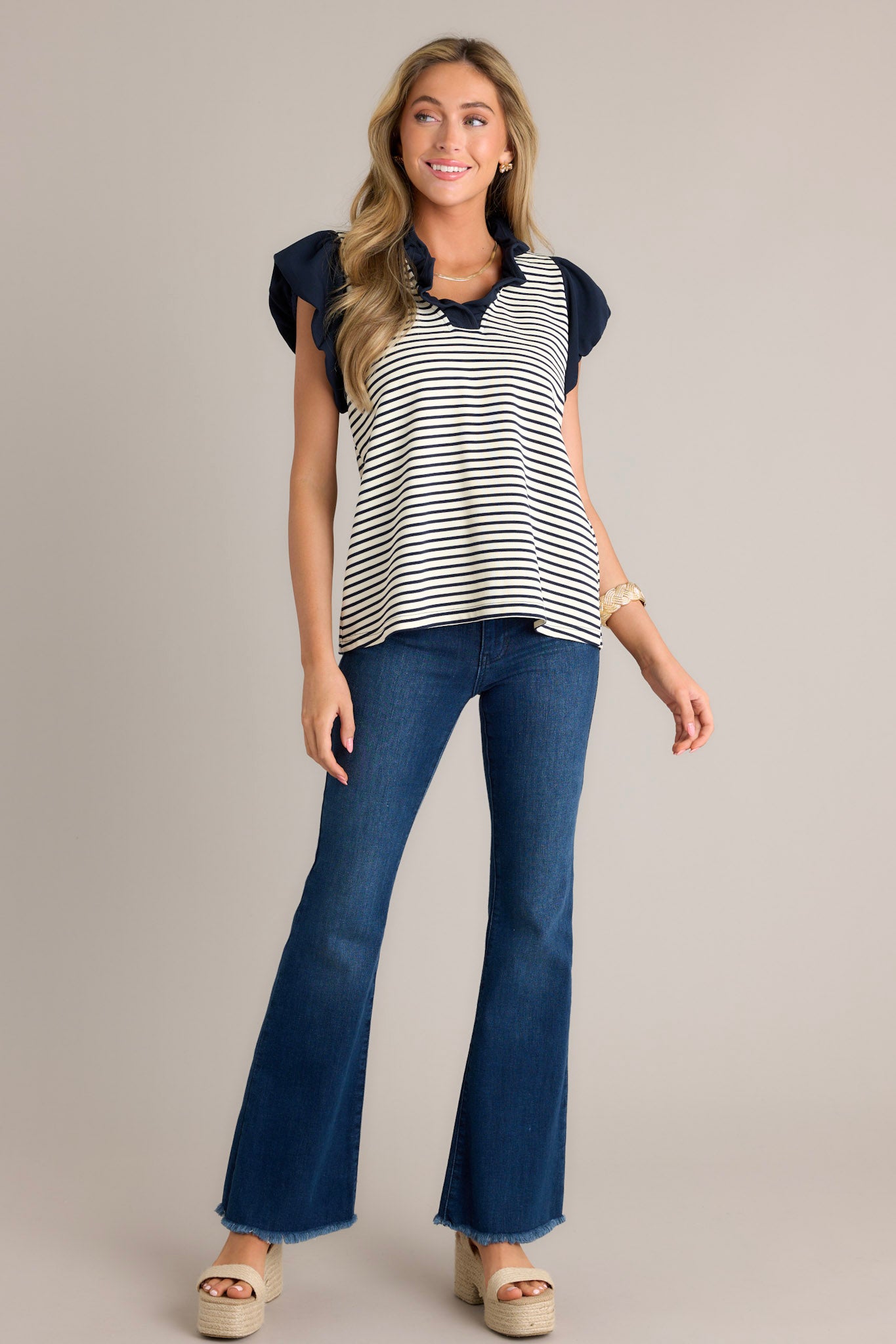 Front view of these jeans that feature a high waist, classic button zipper closure and flared leg.