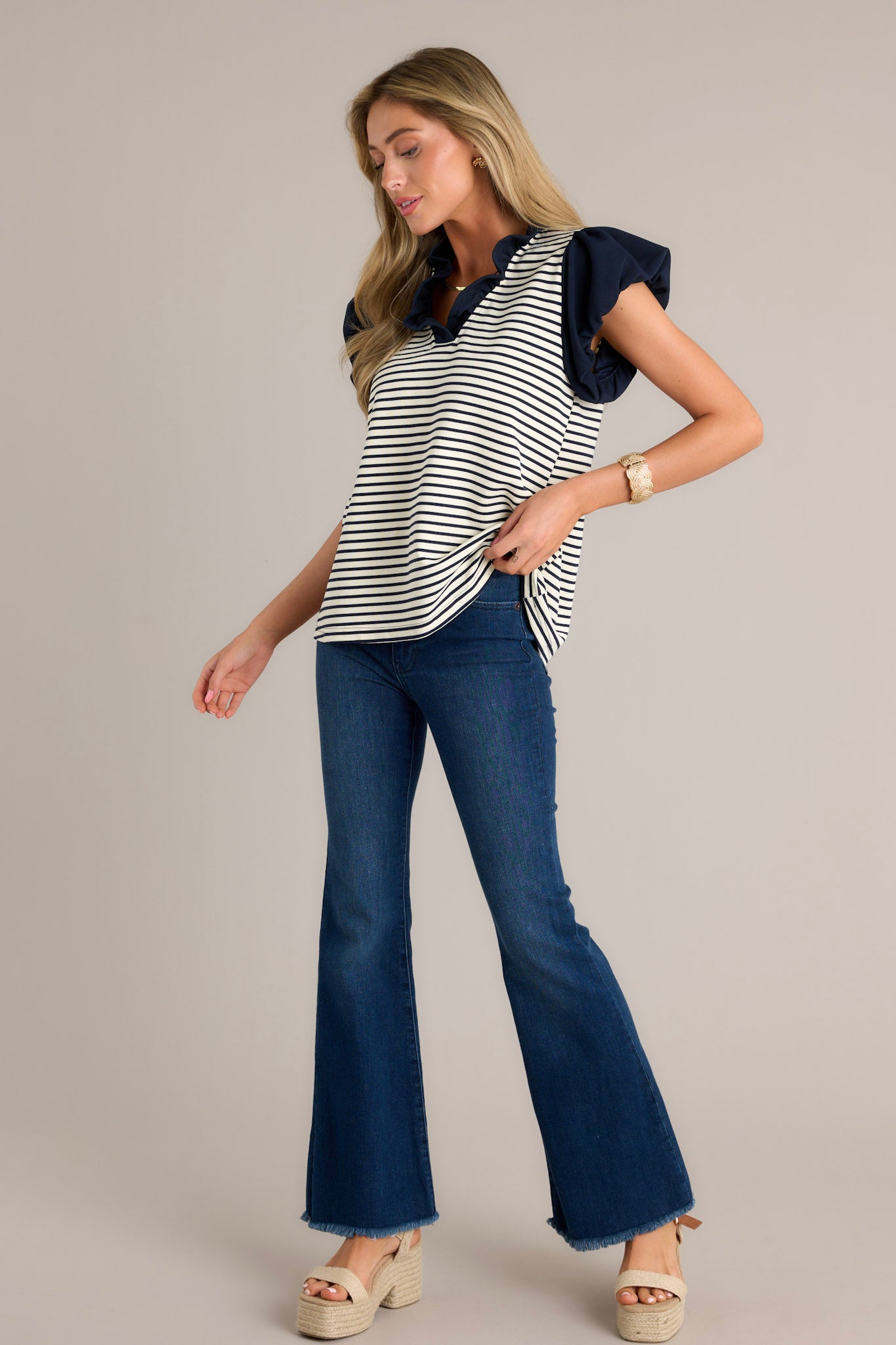 Full body view of these jeans that feature a high waist, classic button zipper closure and flared leg.