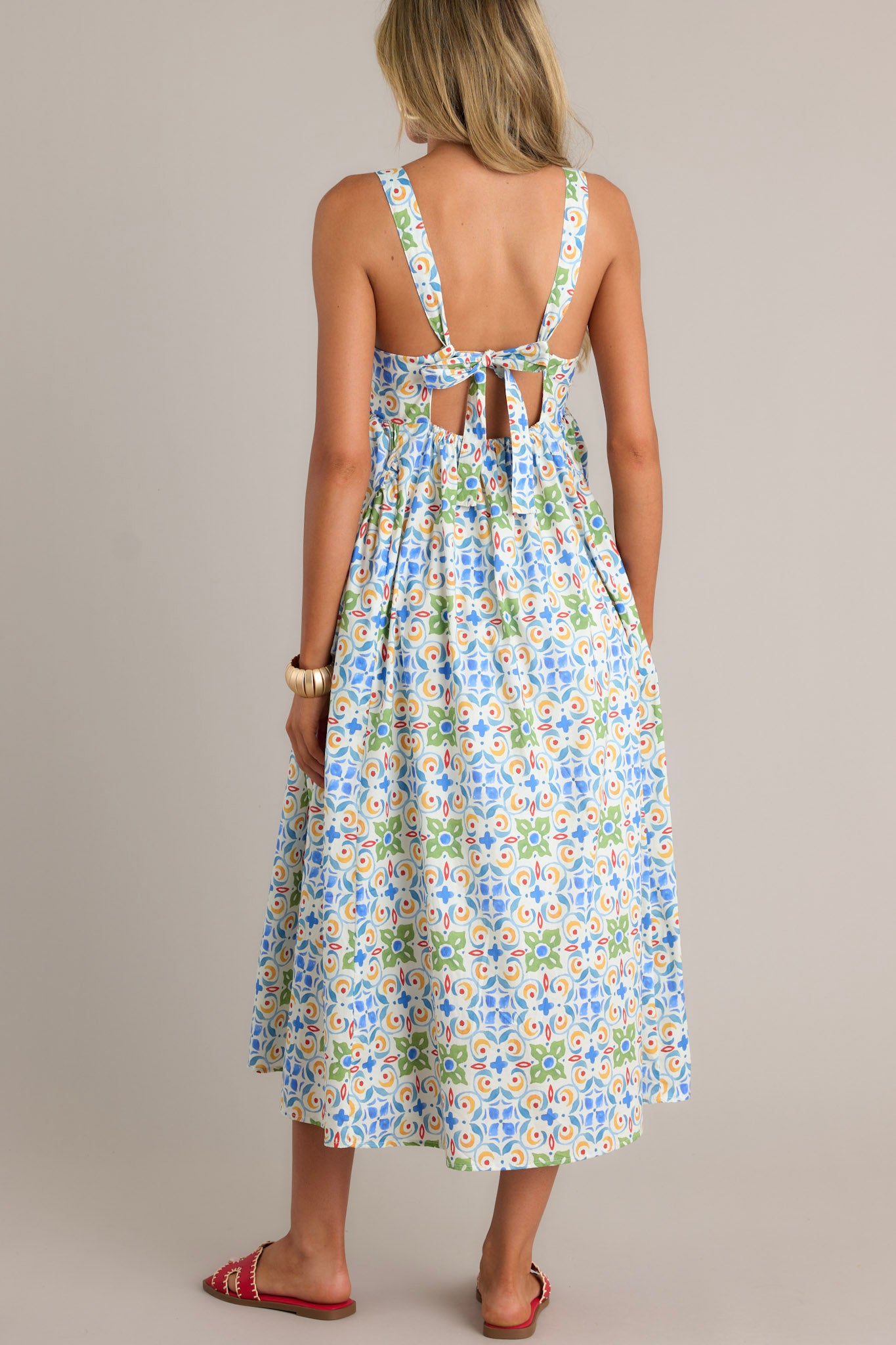 Back view of a white midi dress highlighting the self-tie adjustable straps, colorful pattern, and overall fit.