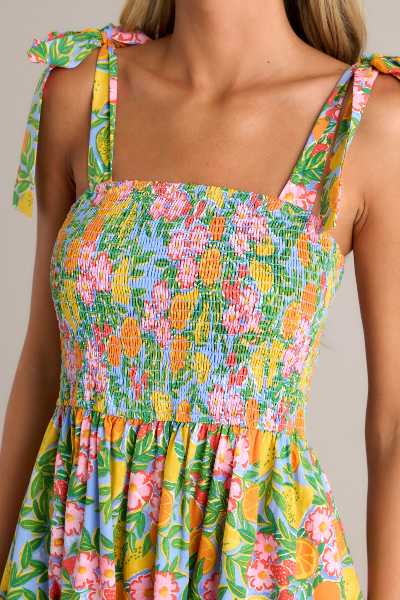 Close-up of the green multi midi dress showing the square neckline, self-tie shoulder straps, and beautiful print.