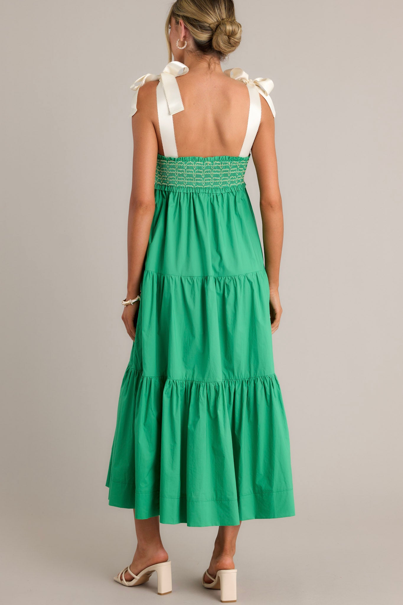 Back view of a green maxi dress highlighting the thick self-tie straps, fully smocked bodice, and overall fit.