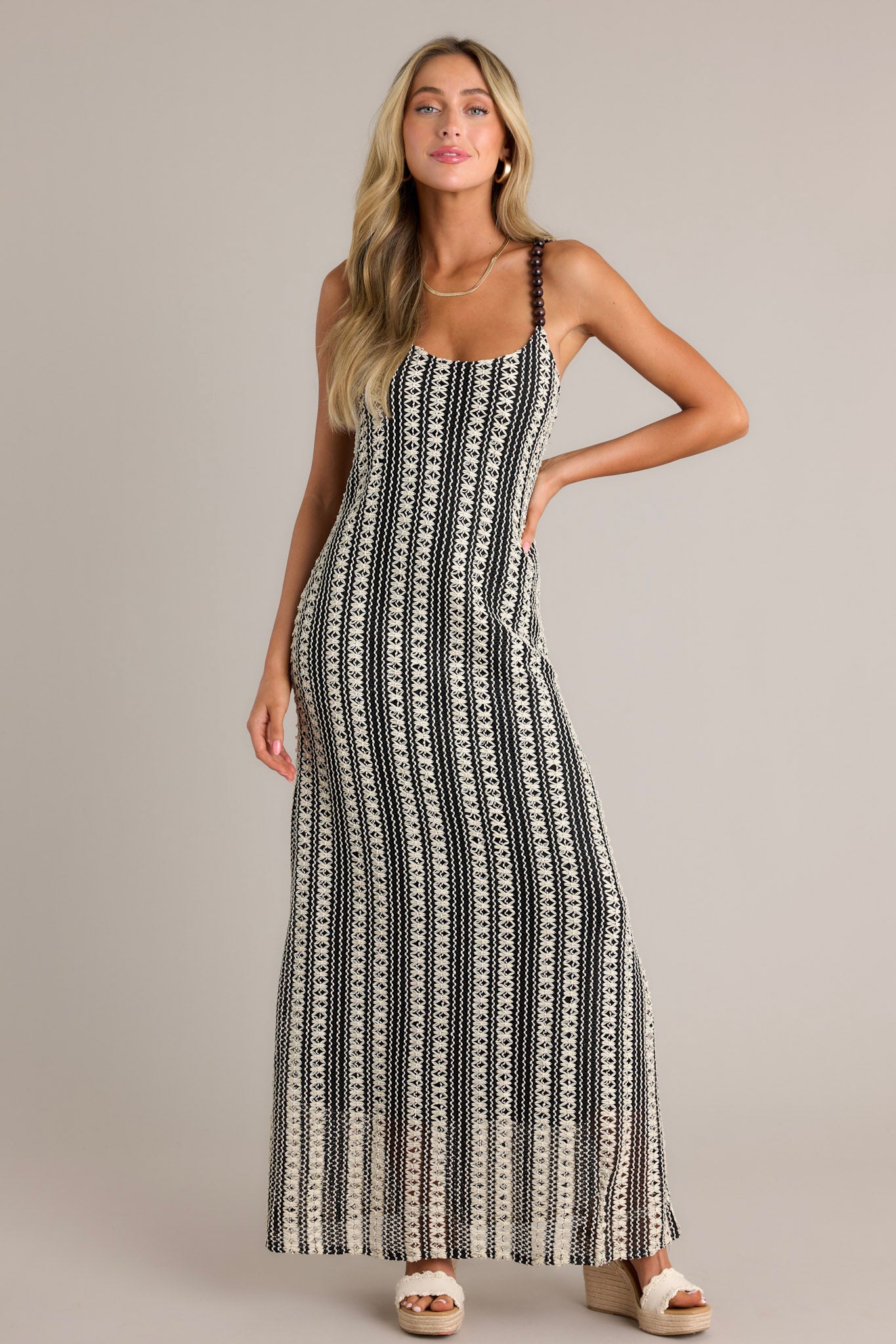 Full length view of a black stripe maxi dress with a scoop neckline, fully beaded straps, a knitted design, and a vertical stripe pattern