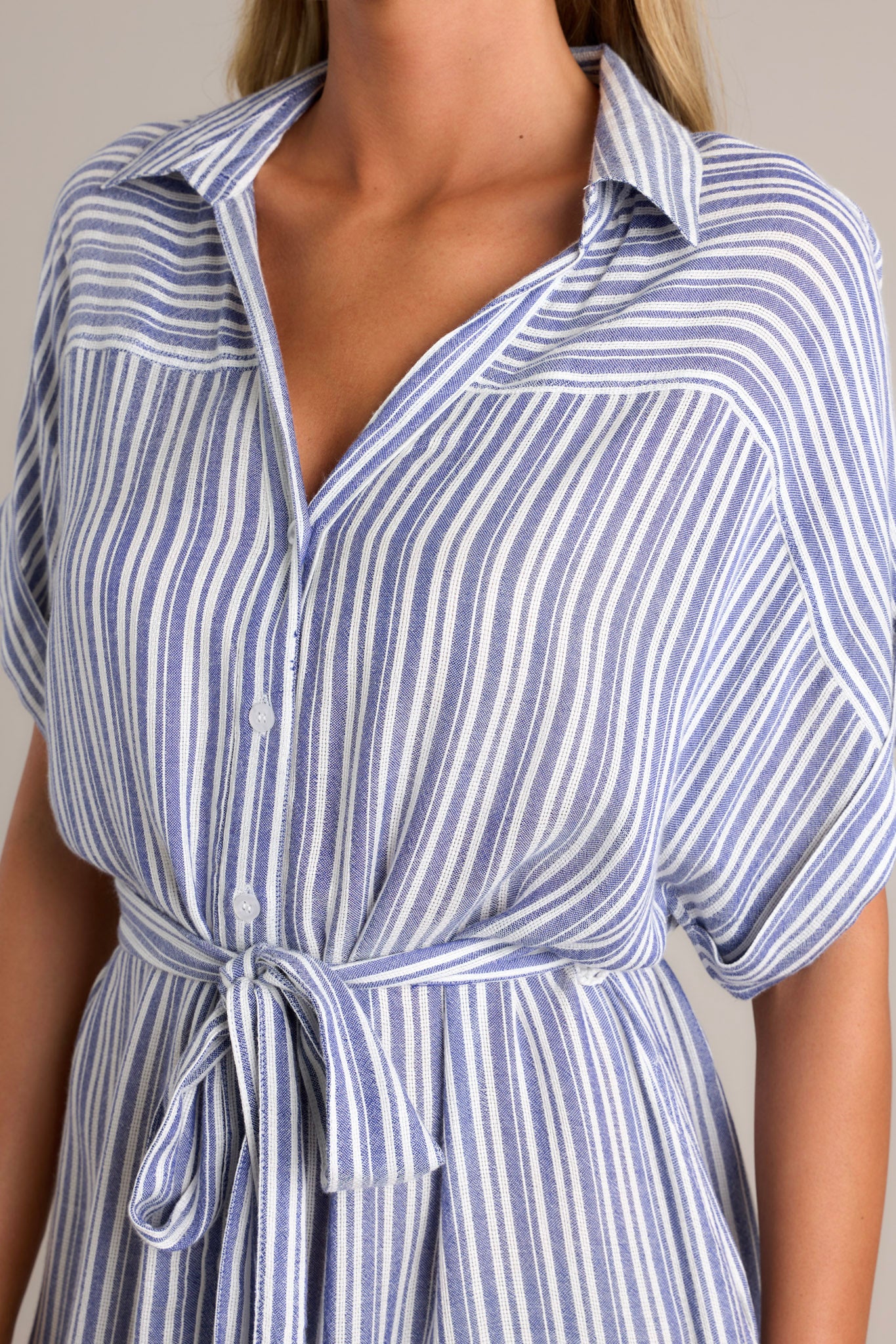 Close-up of the blue stripe midi dress showing the collared v-neckline, functional button front, and self-tie drawstring belt.