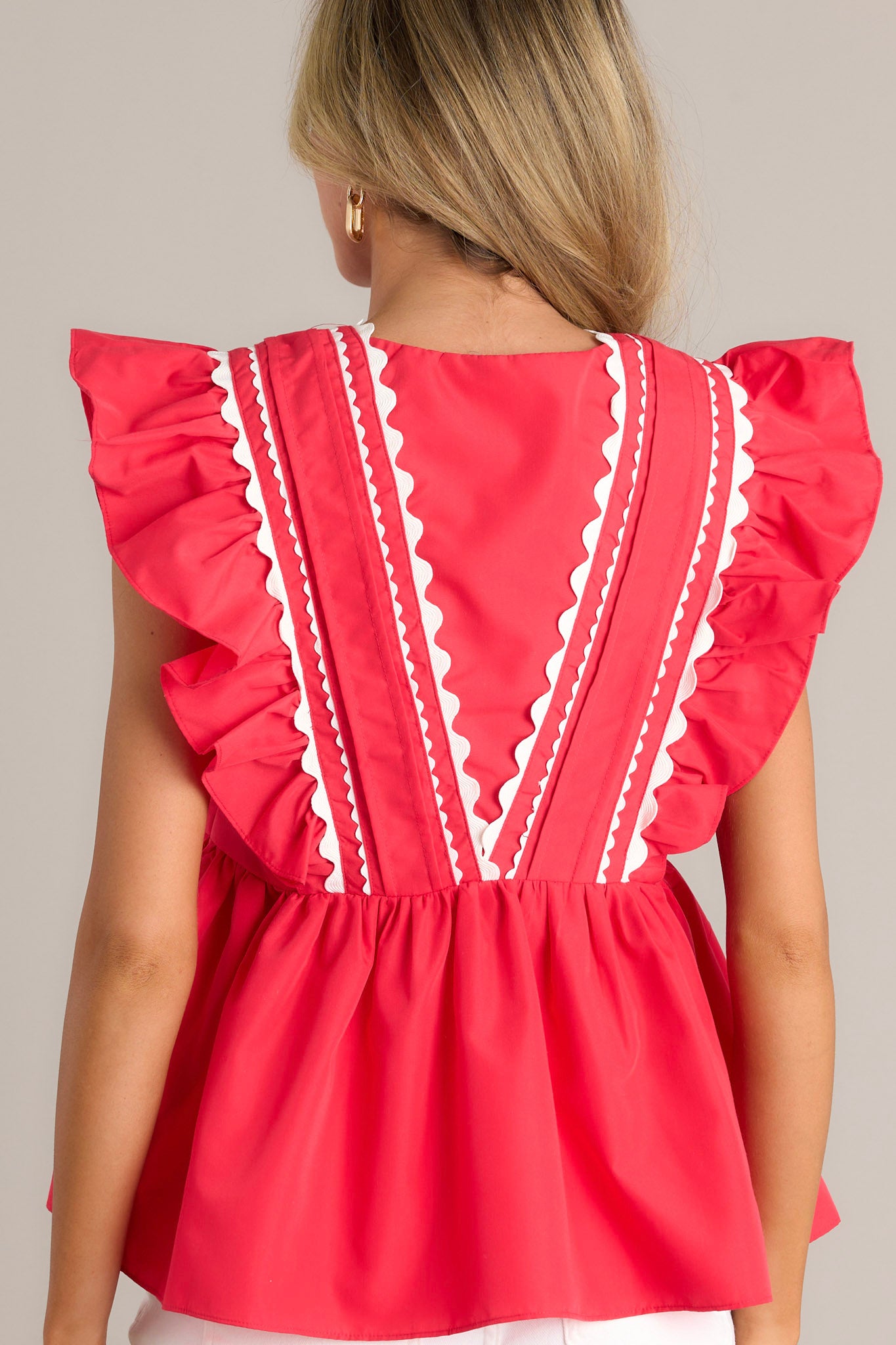 Back view of a red babydoll top highlighting the overall fit and flutter sleeves.