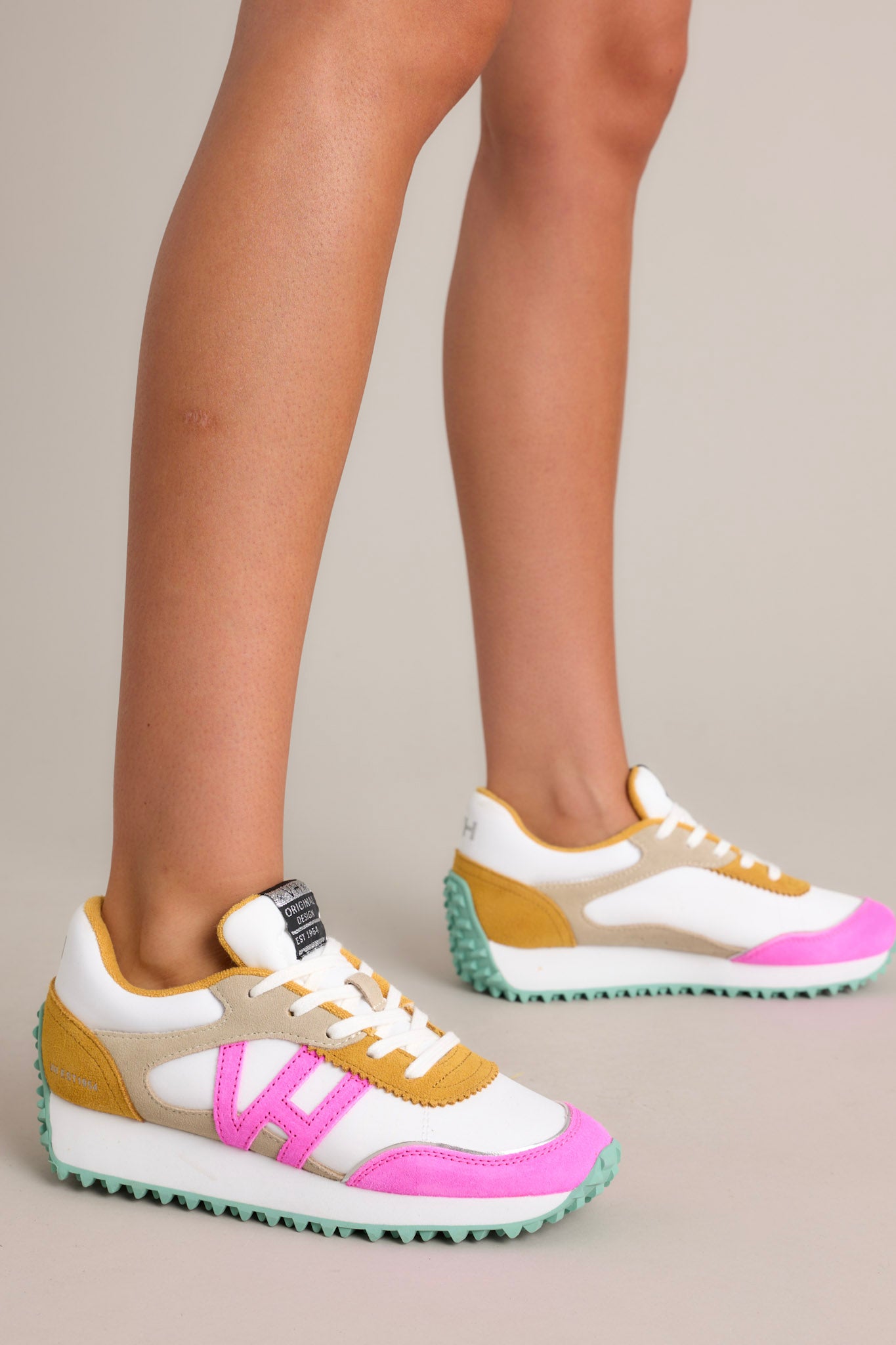 These sneakers feature a rounded toe, functional laces, pops of color, a slight platform, and a heavily textured sole.