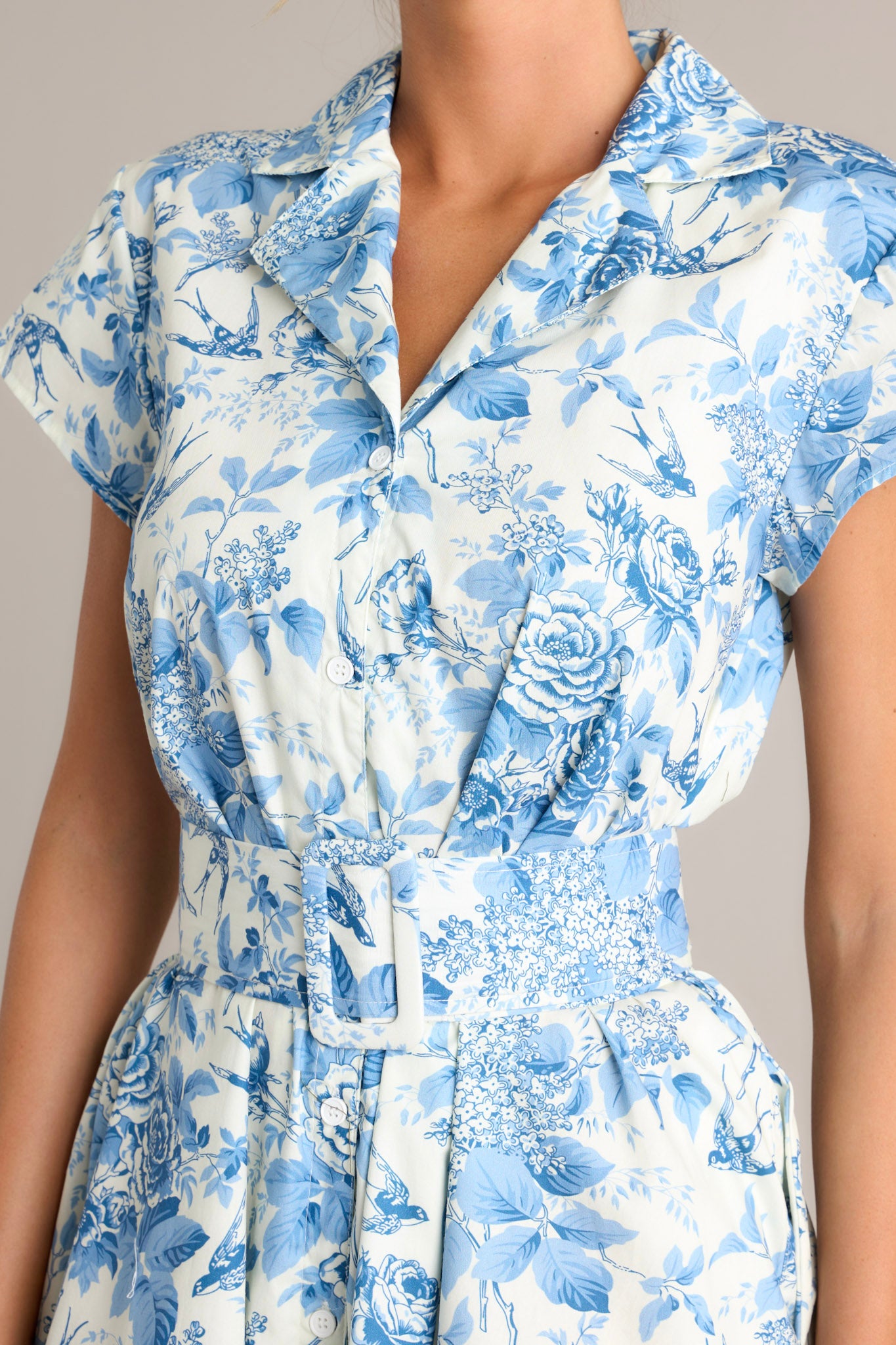 Close-up of the dress showing the notched lapel collared v-neckline, full button front, and functional hip pockets.