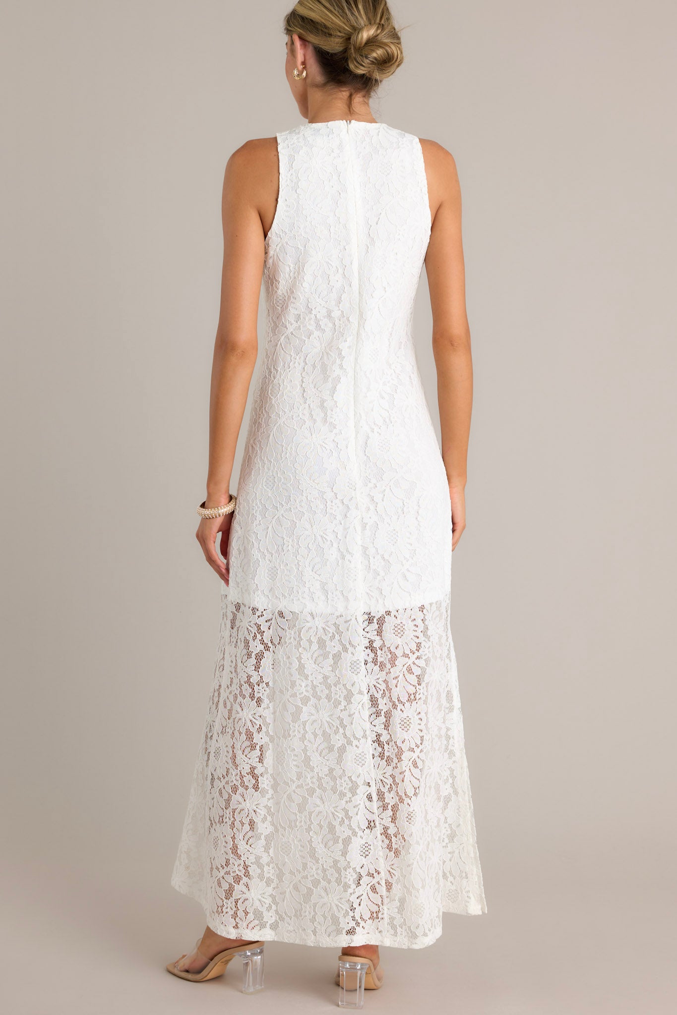 Back view of a dress highlighting the lace overlay, lining that extends from the shoulder to the mid-thigh, and overall fit.