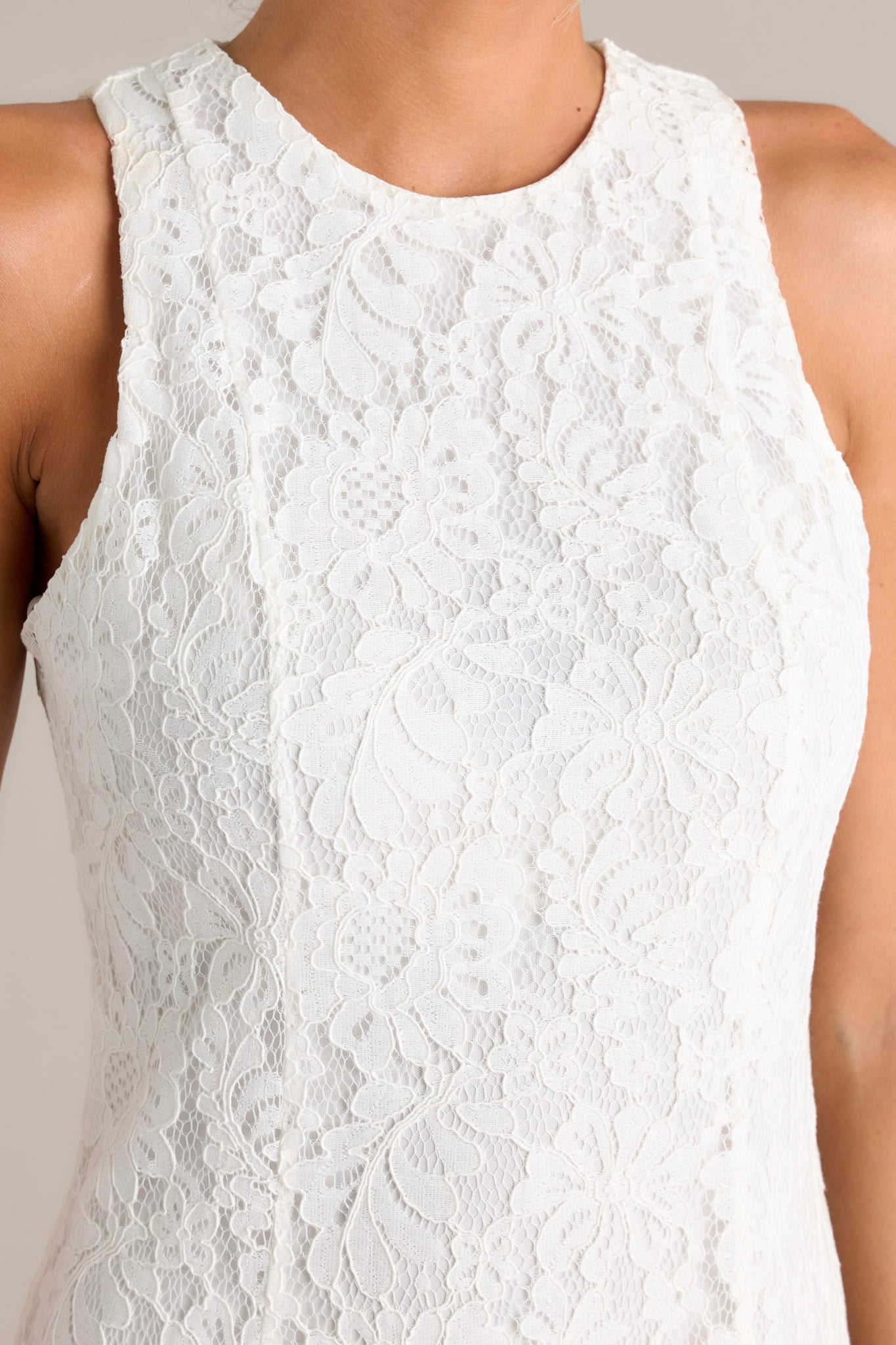 Close-up of the dress showing the high round neckline and lace overlay.