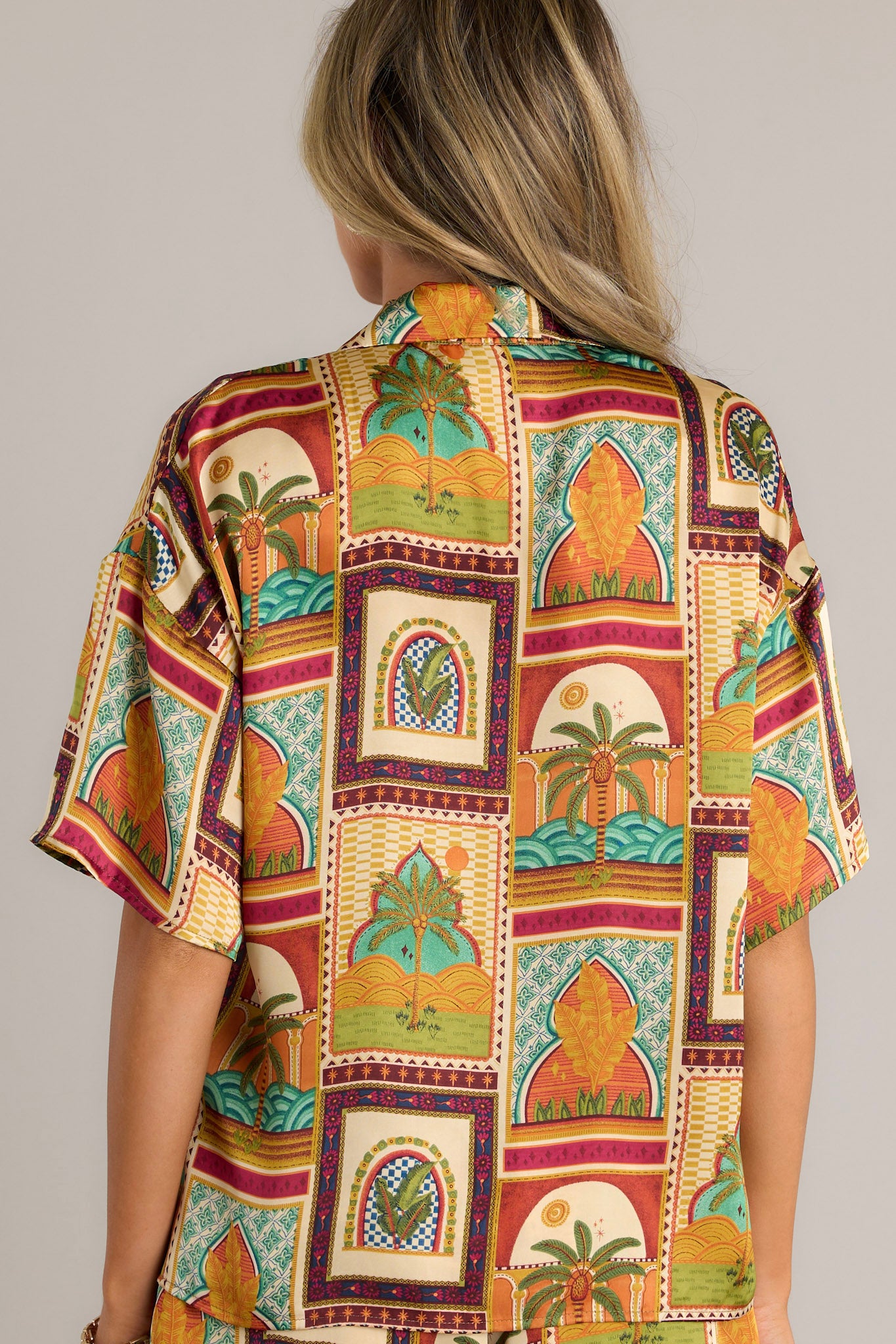 Back view of a mustard top highlighting the unique print, lightweight fabric, and overall fit.